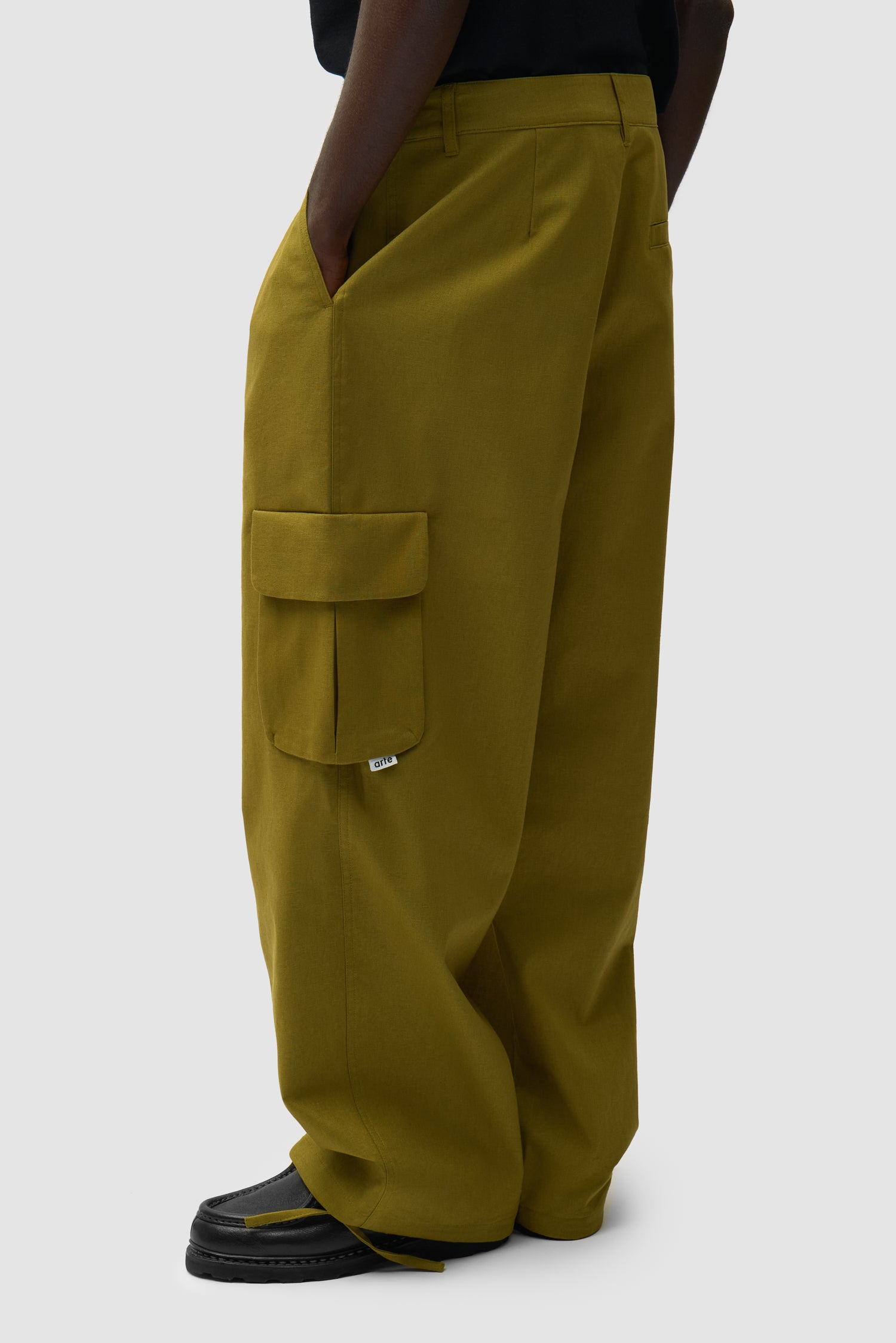 Pantalon cargo en lin vert porté par un mannequin, vue de profil à mi-corps