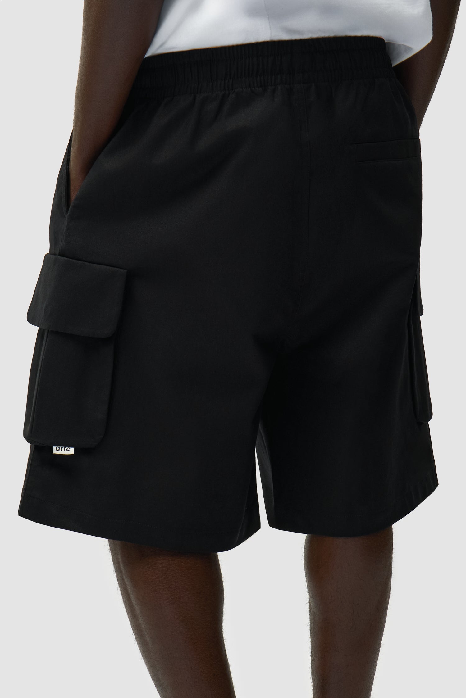Vue détaillée du short cargo en lin noir, montrant les poches arrière