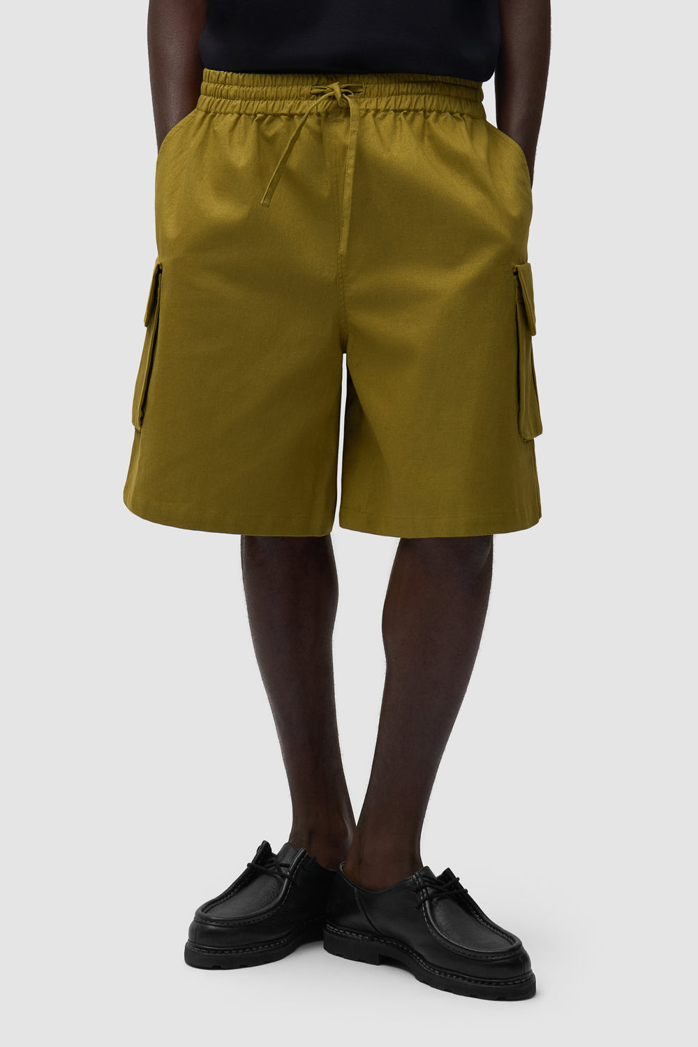 Short cargo en lin vert porté par un mannequin, vue de face en demi-corps