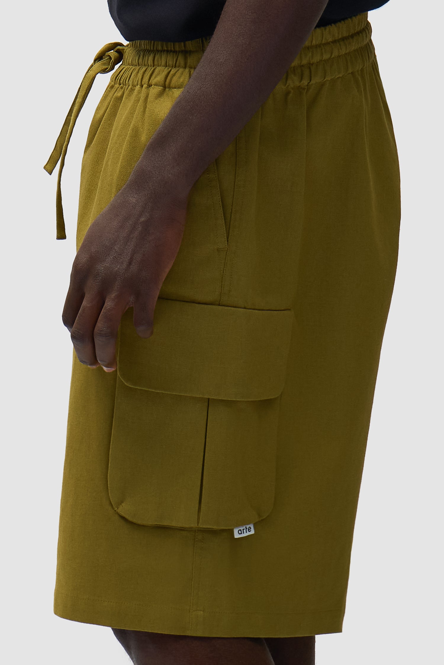 Short cargo en lin vert porté par un mannequin, vue de profil en pied