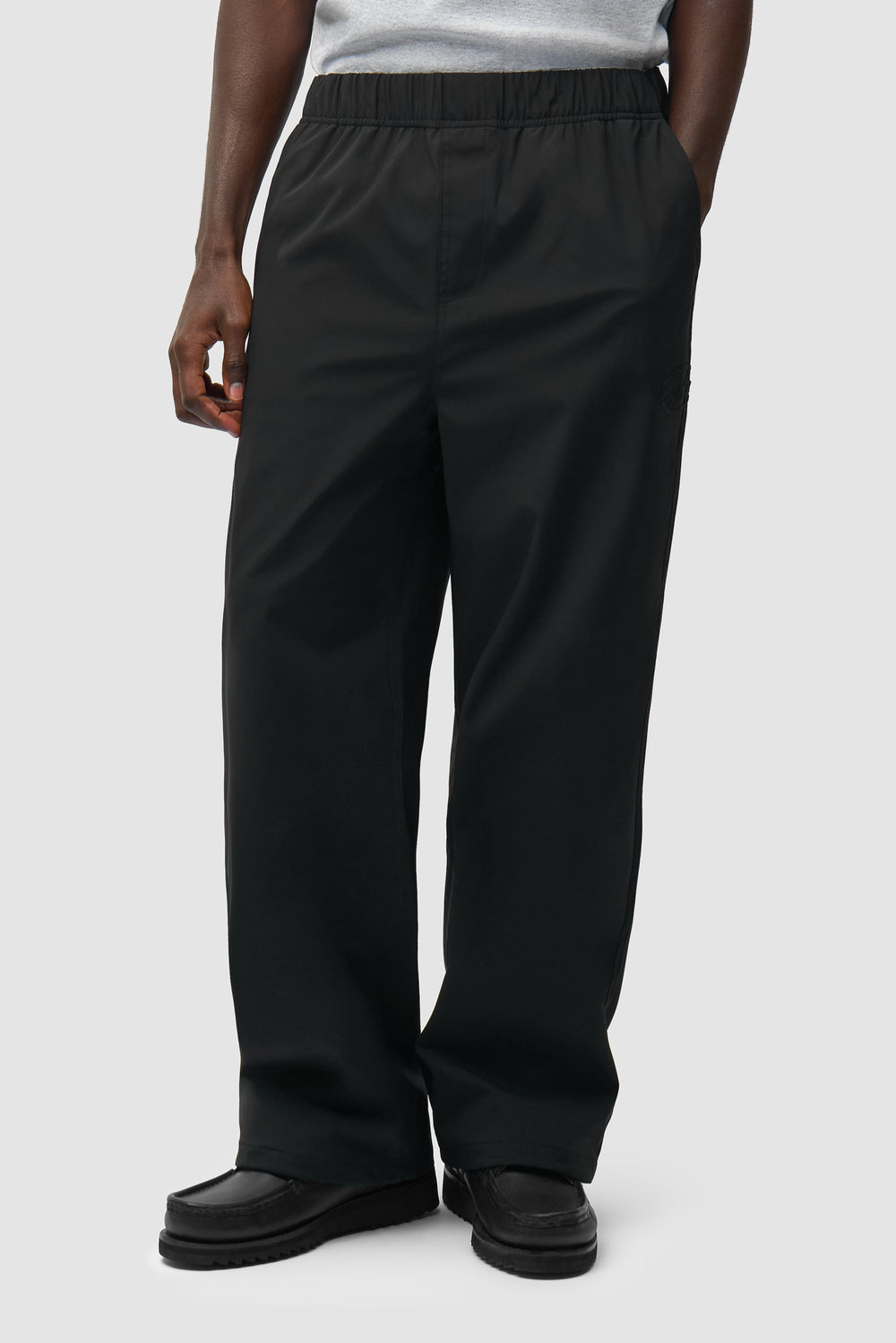 Branded Track Pants in Black worn by a model, half-body front view