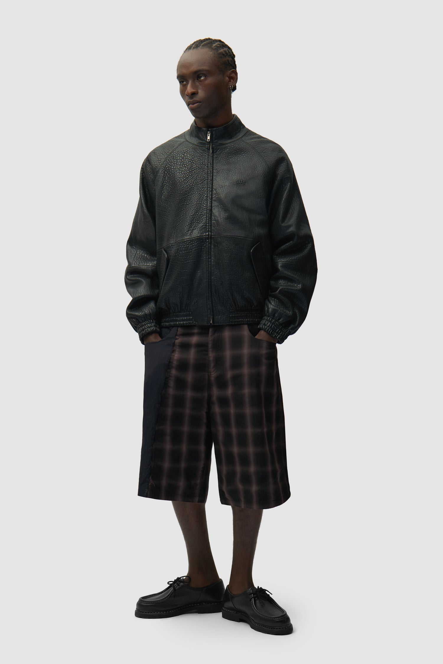 Veste en cuir à col haut, couleur noire, portée par un mannequin, vue de face en pied