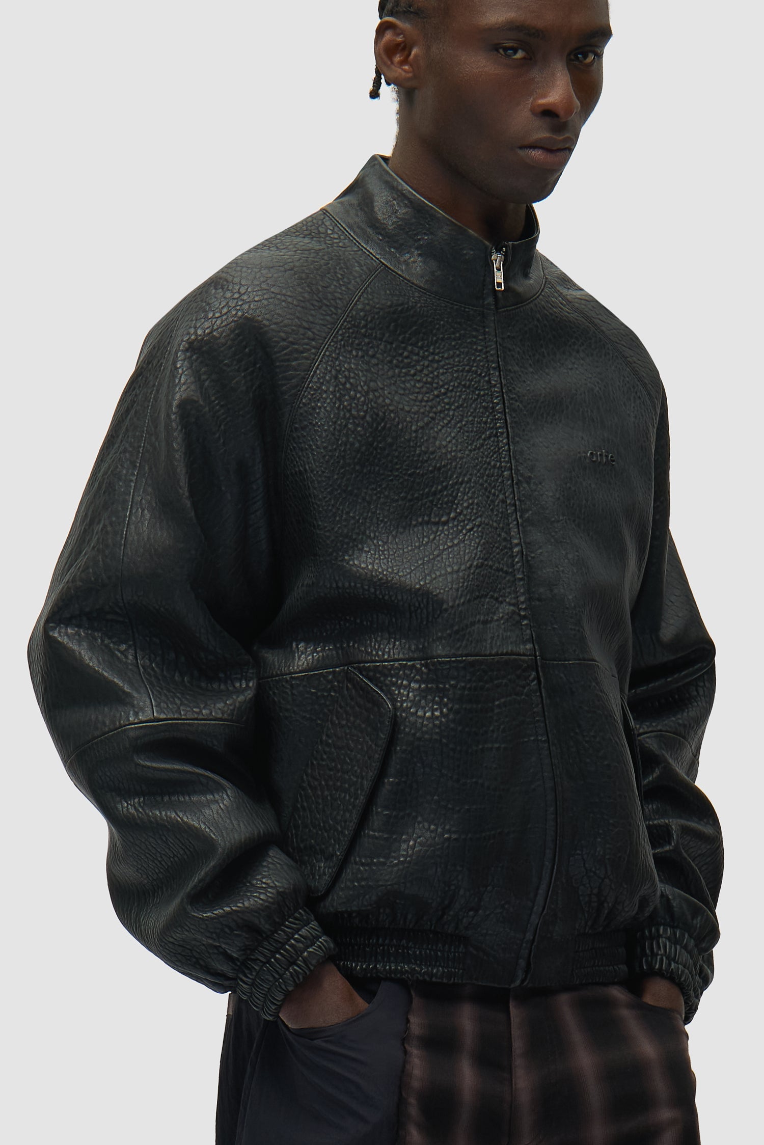 Veste en cuir à col haut, couleur noire, portée par un mannequin, vue de profil à mi-corps