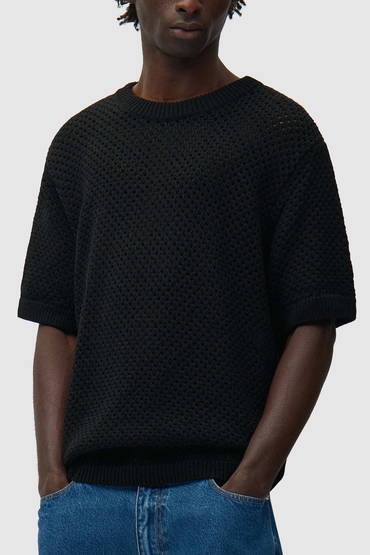 T-shirt noir au crochet porté par un mannequin, vue de profil à mi-corps