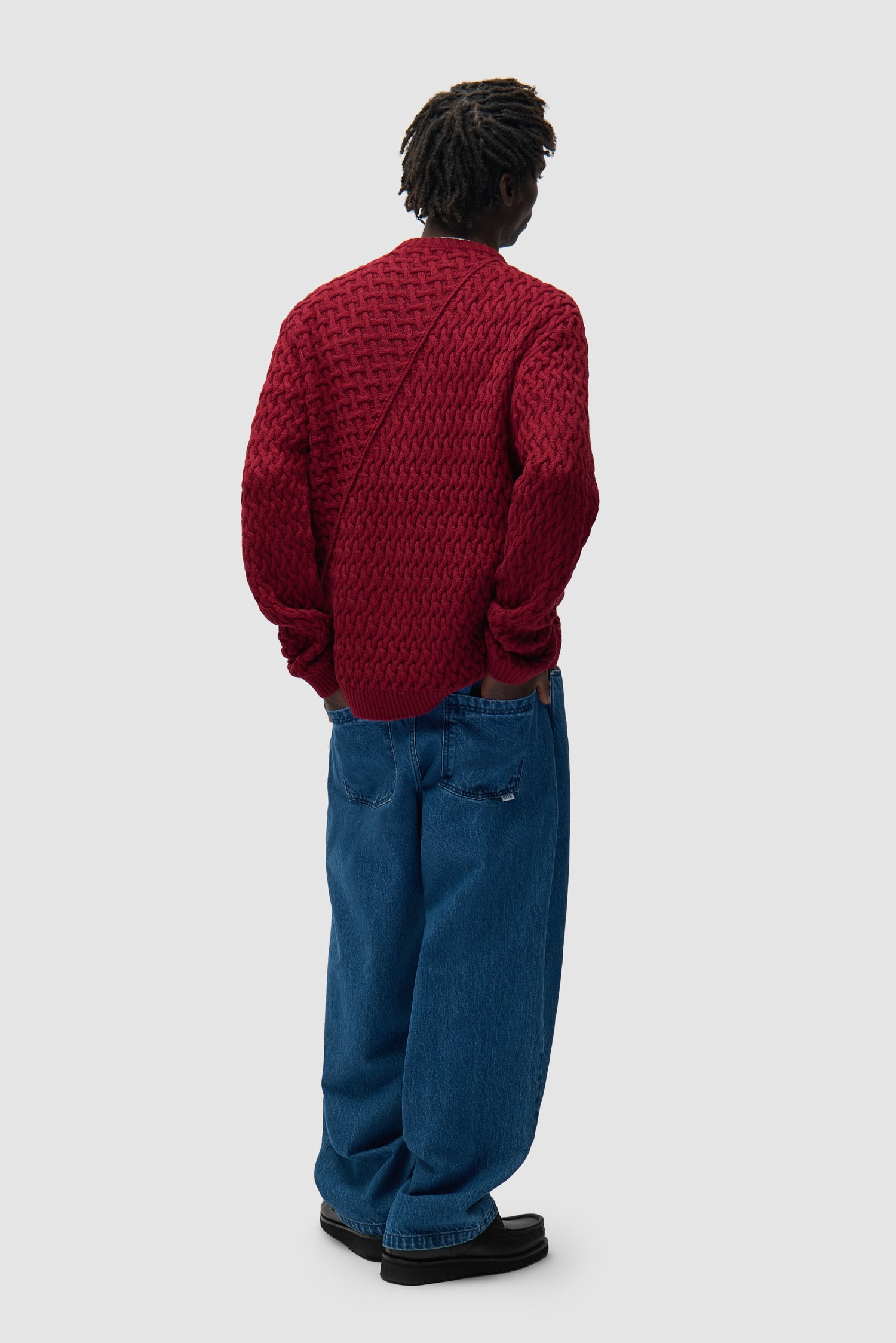 Pull à logo déformé couleur bordeaux porté par un mannequin, vue arrière intégrale