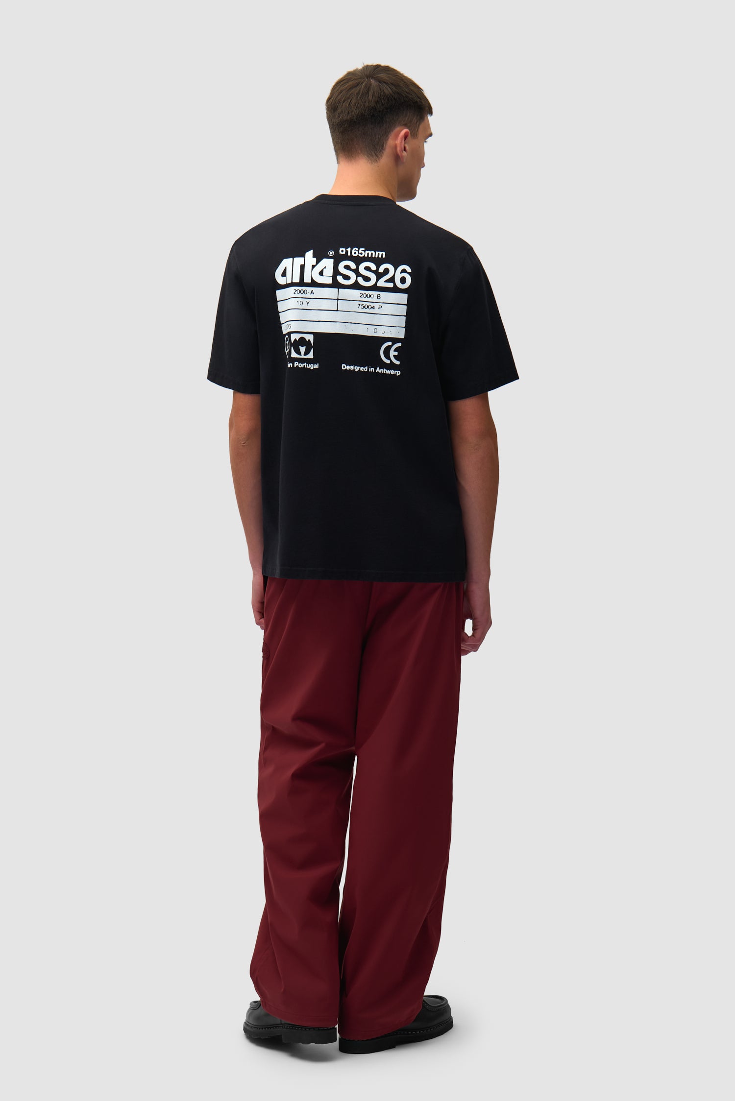 T-shirt SS26 Back en noir porté par un mannequin, vue de profil en pied