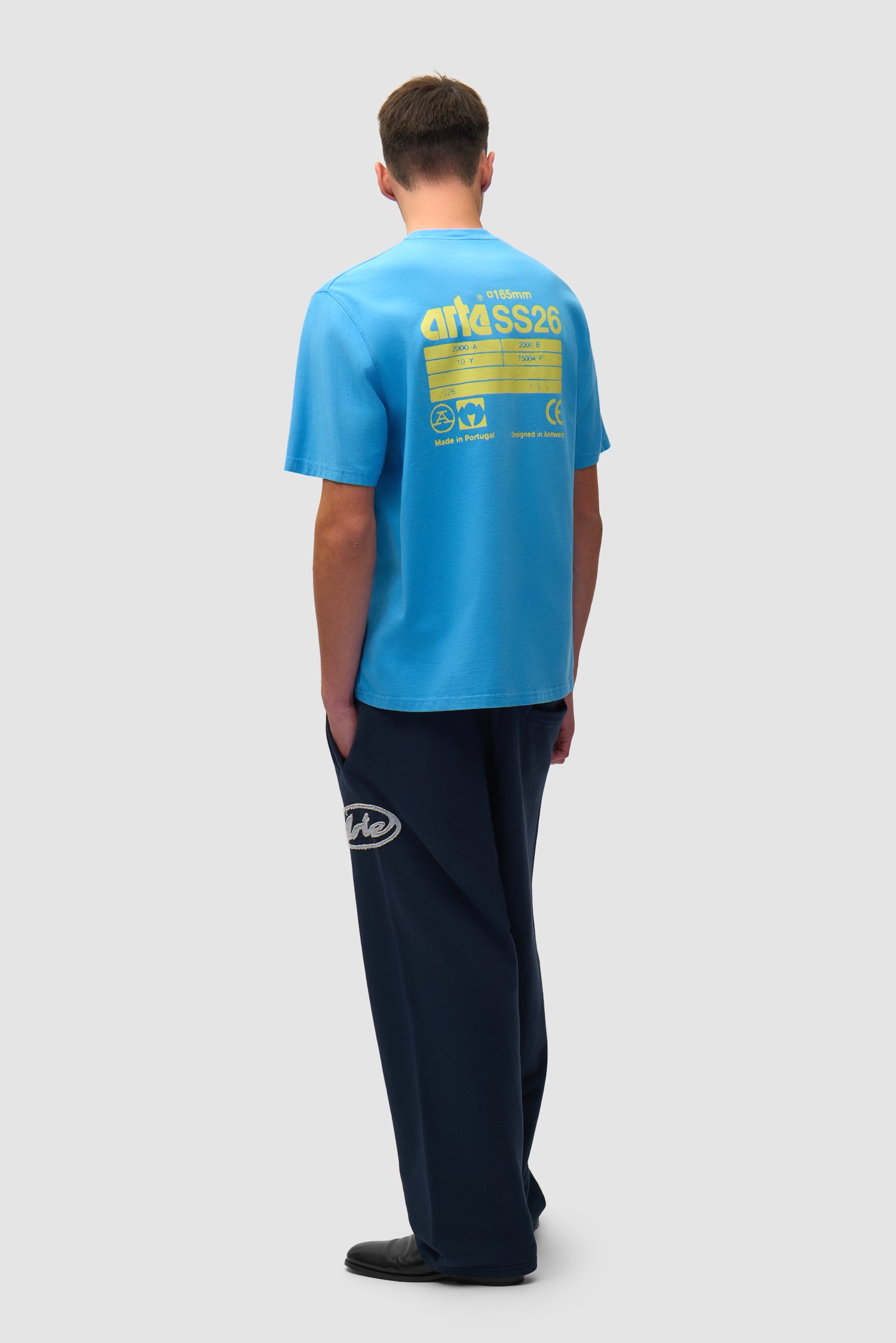 T-shirt SS26 bleu porté par un mannequin, vue arrière intégrale