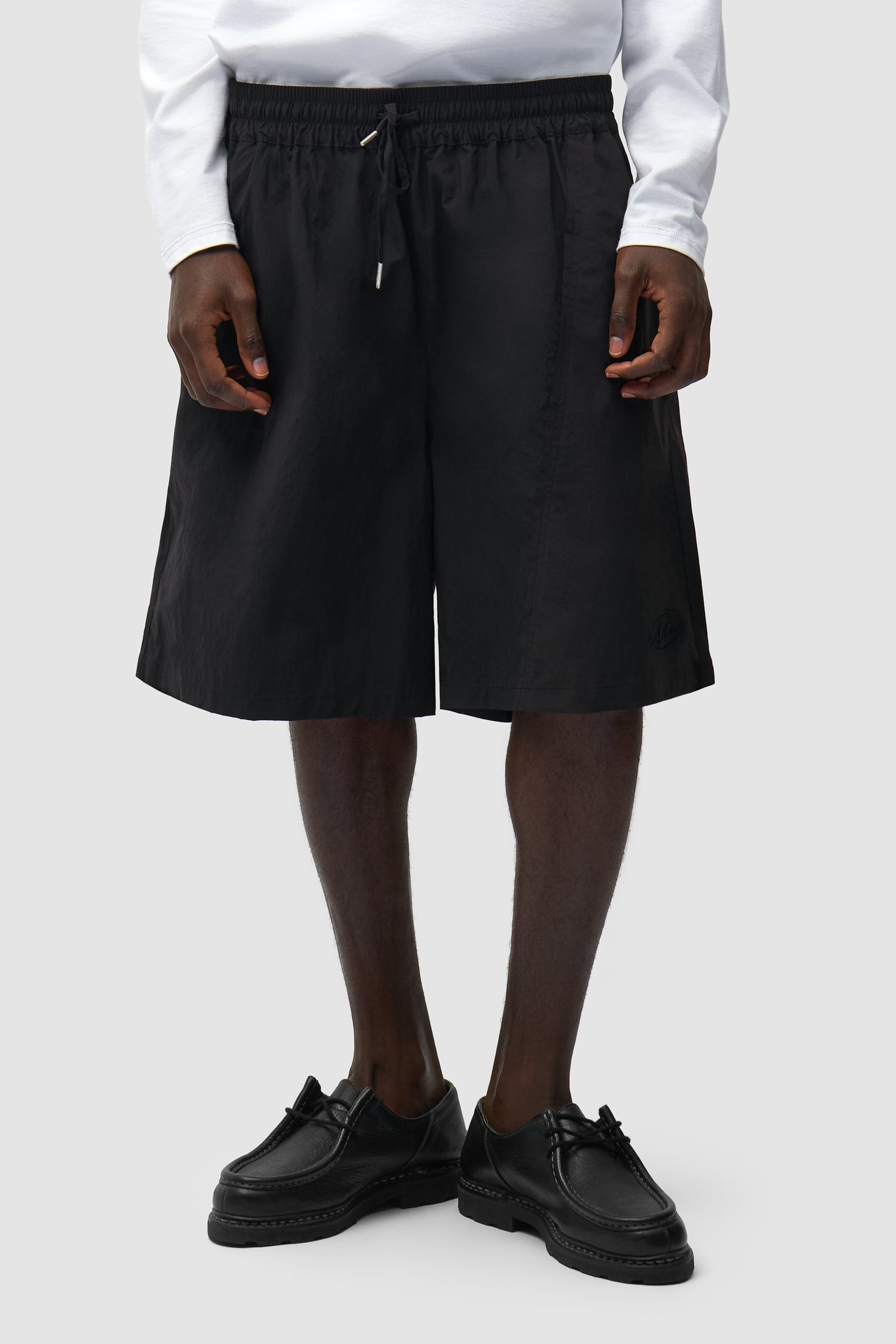 Short déformé noir porté par un mannequin, vue de face en demi-corps