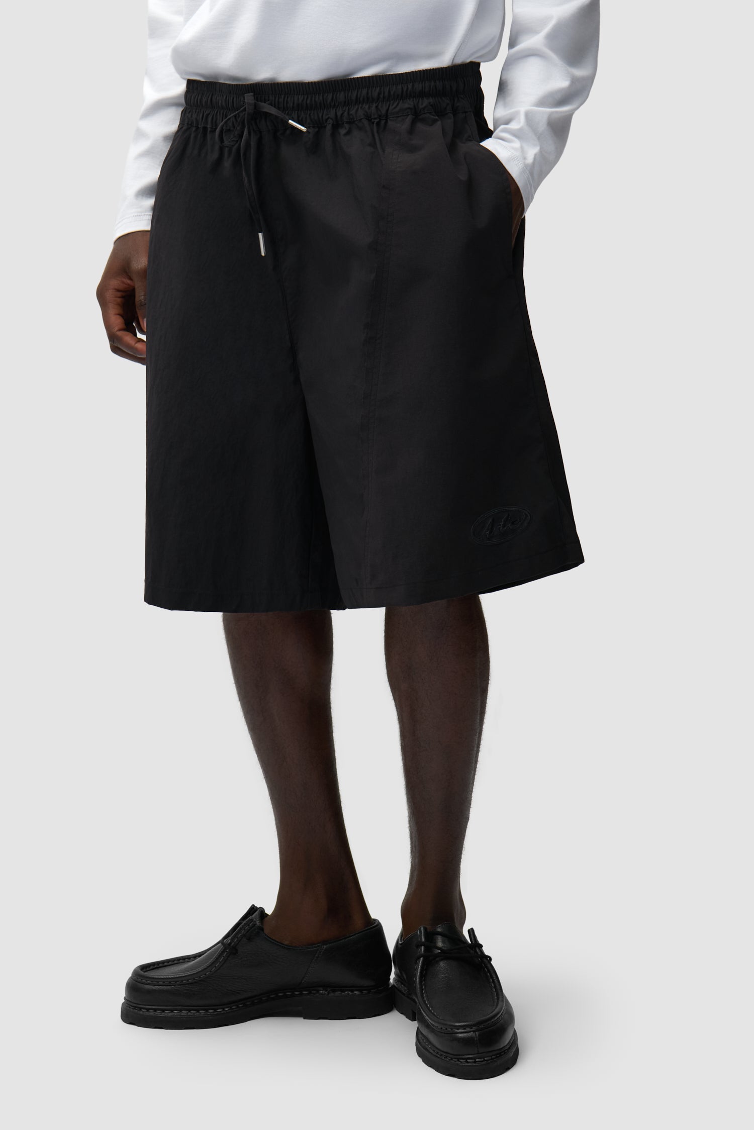 Short déformé noir porté par un mannequin, vue de profil à mi-corps