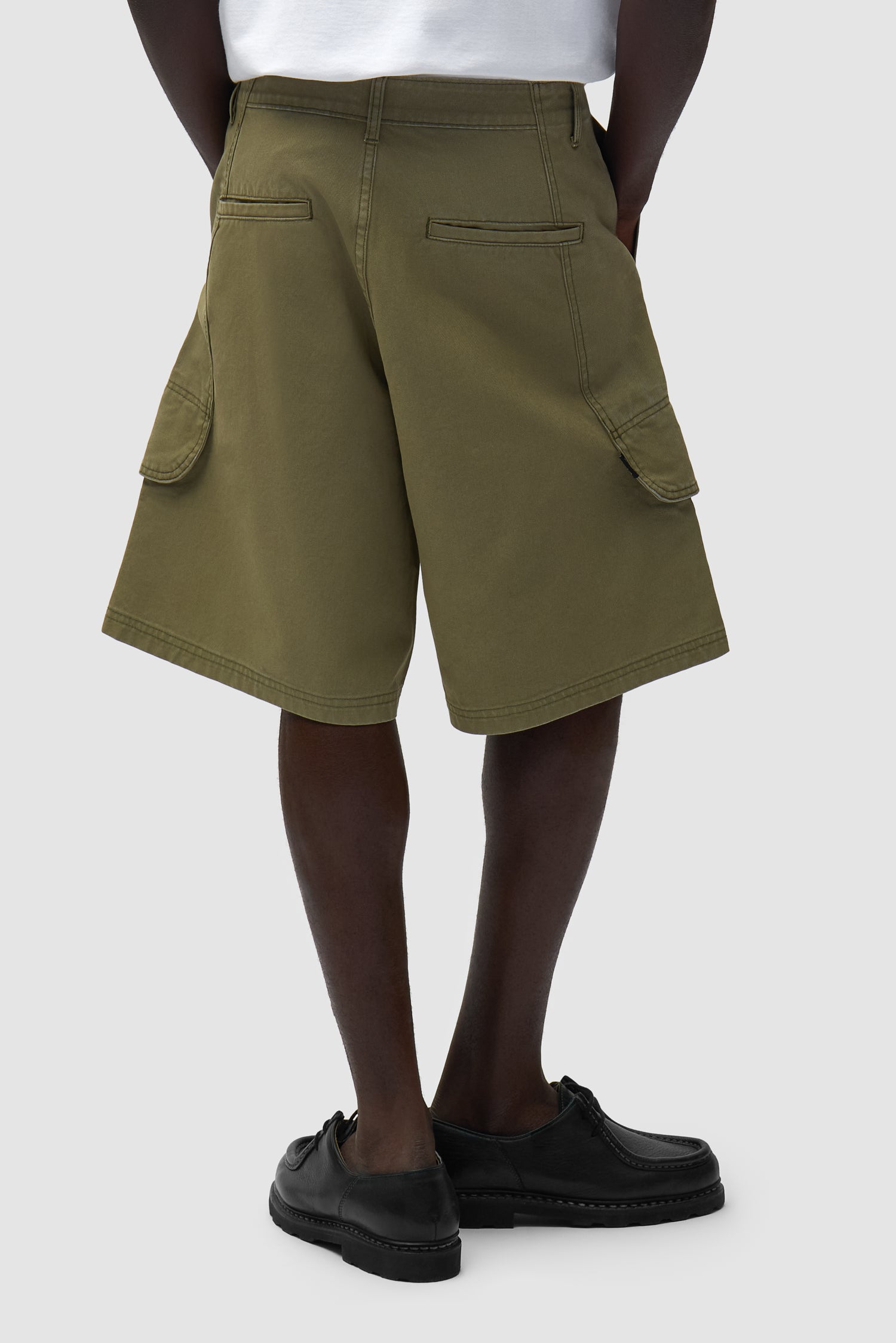 Short cargo en toile vert porté par un mannequin, vue de dos à mi-corps