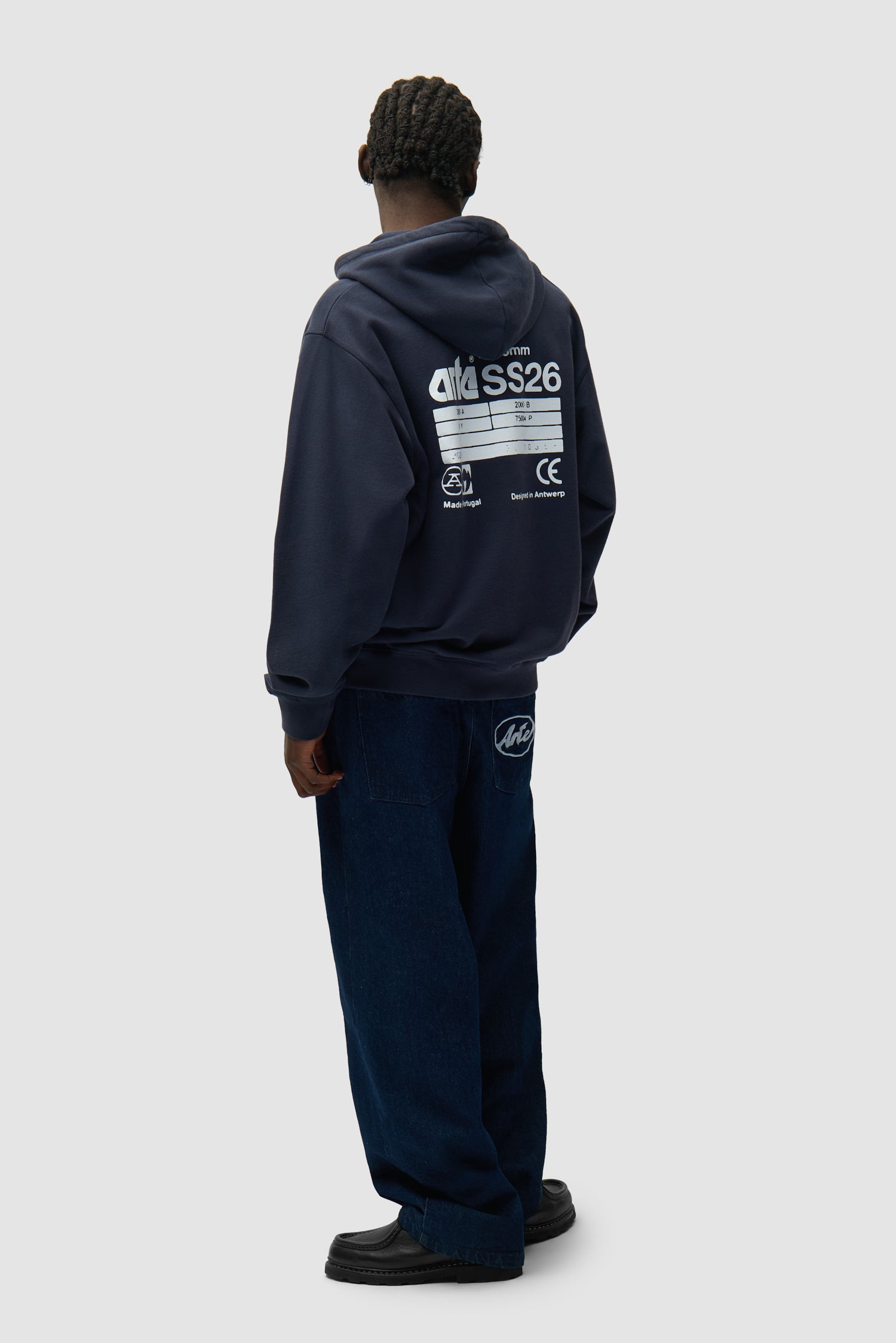 Dos du sweat à capuche SS26 bleu marine porté par un mannequin, vue de profil en pied