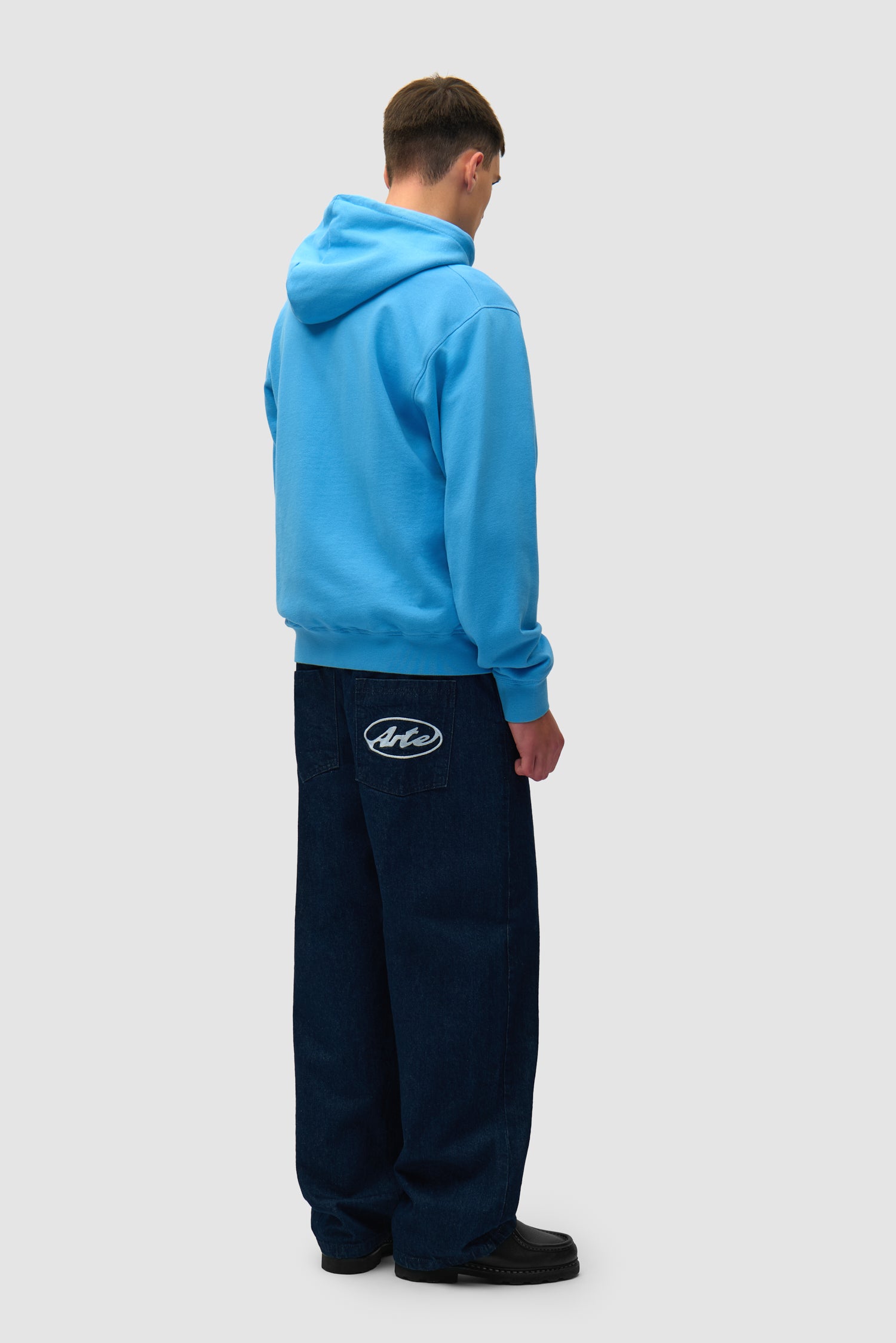 Collage Logo Hoodie in Blue worn by a model, full-body back view