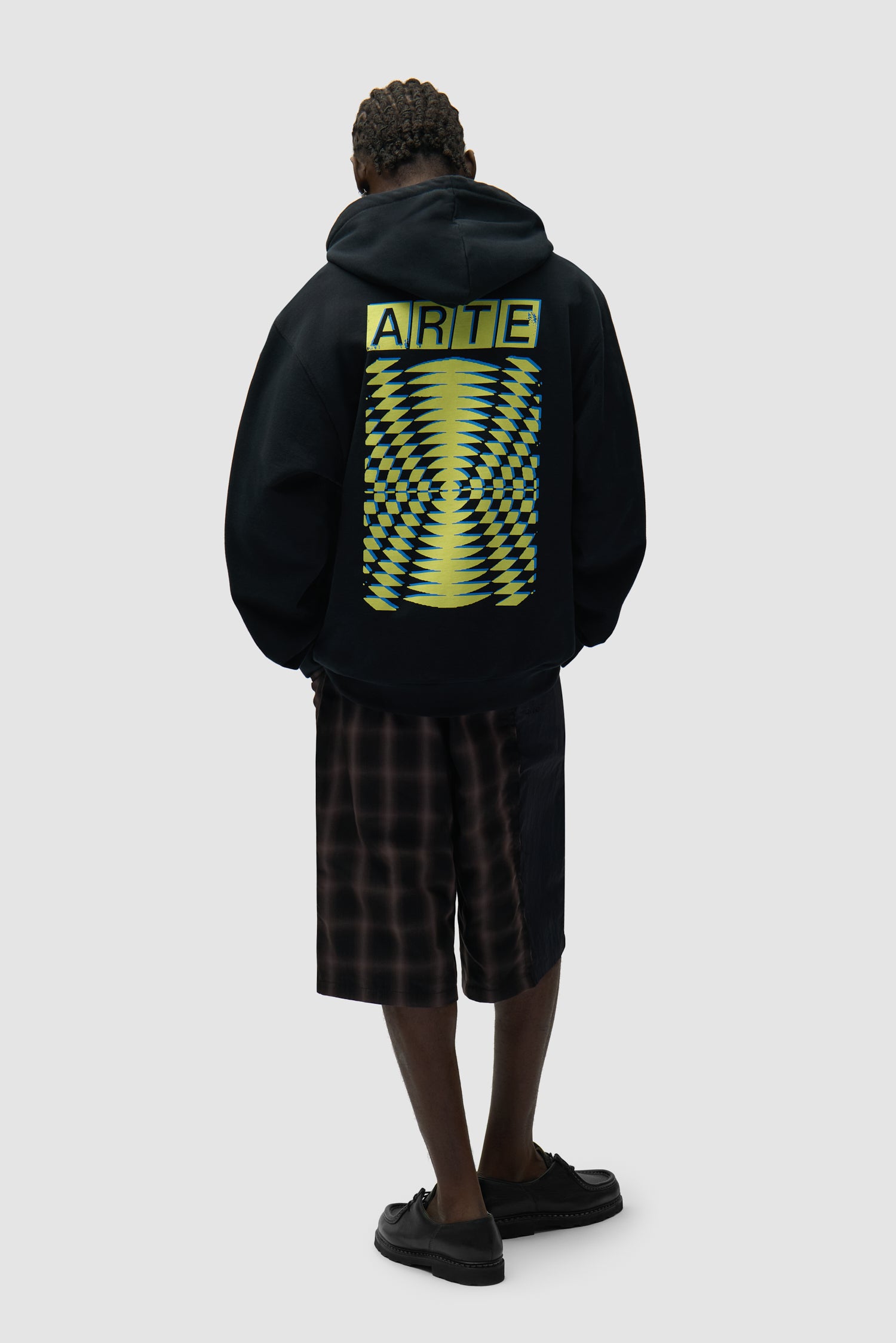 Back Abstract Hoodie in Black worn by a model, full-body side view