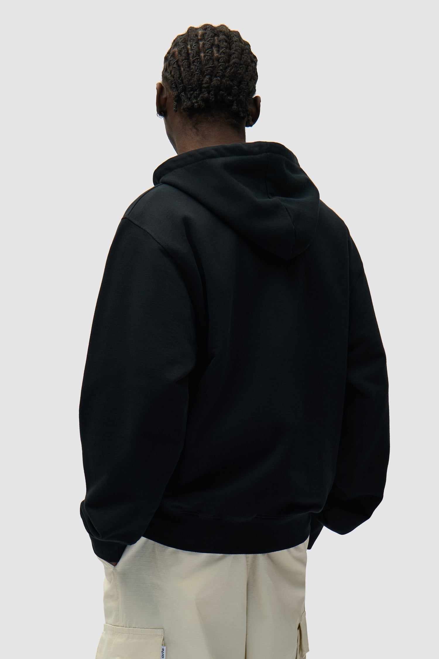 Sweat à capuche zippé avec logo circulaire, couleur noir, porté par un mannequin, vue de dos à mi-corps