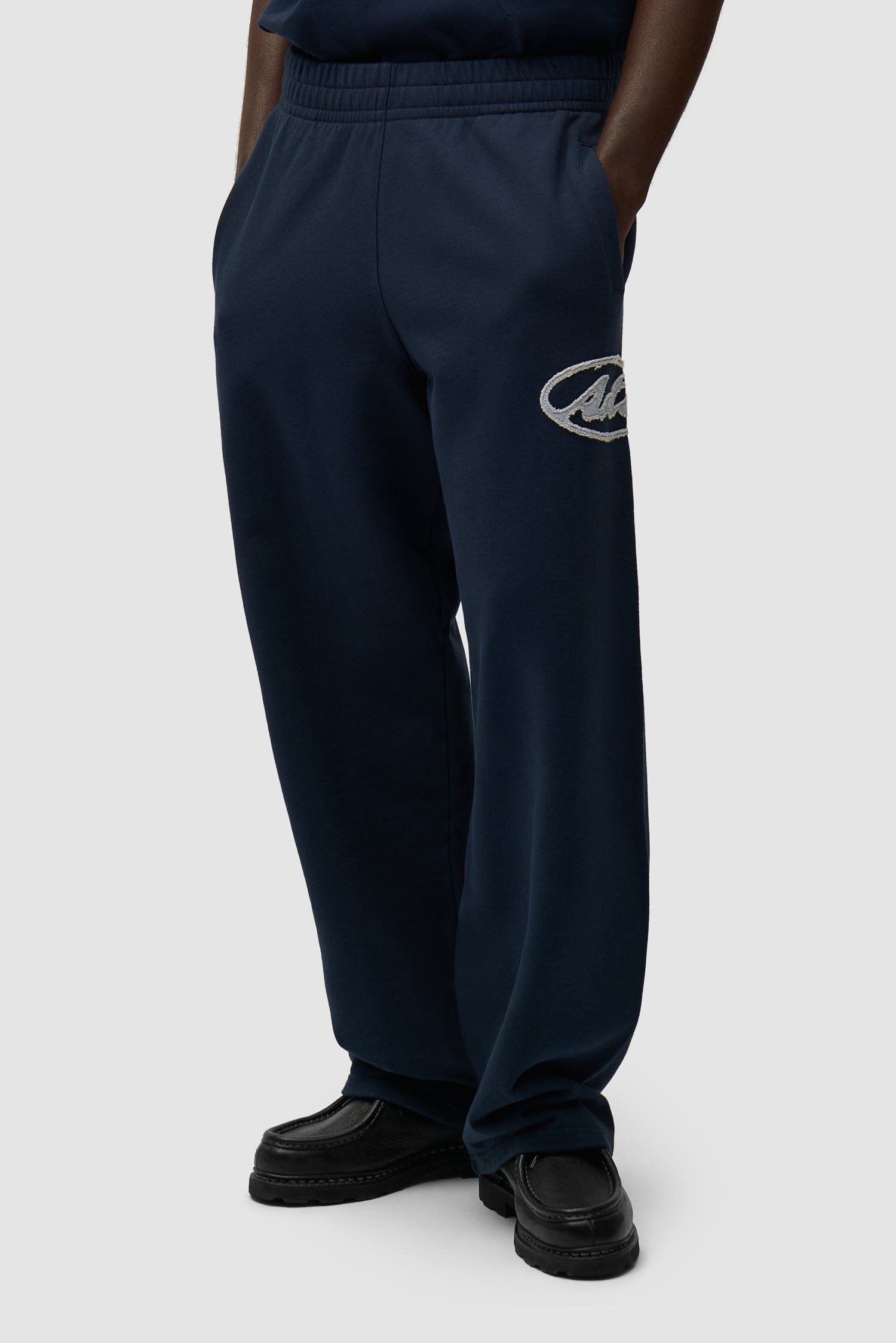 Pantalon de survêtement avec logo Circle Patch en bleu marine porté par un mannequin, vue de face à mi-corps