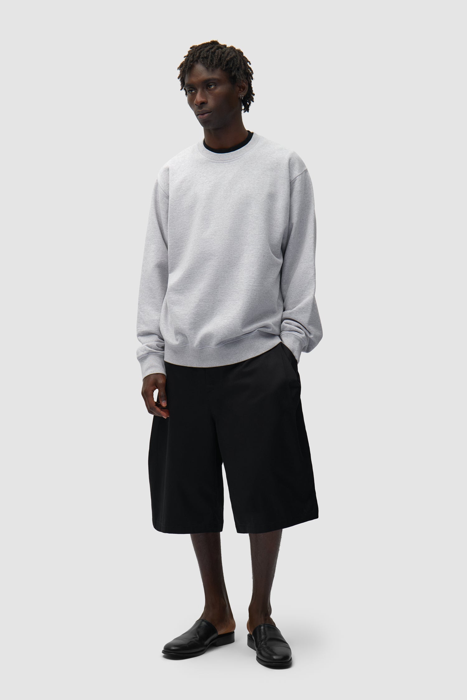 Dos SS26 Crewneck en gris porté par un mannequin, vue de face en pied