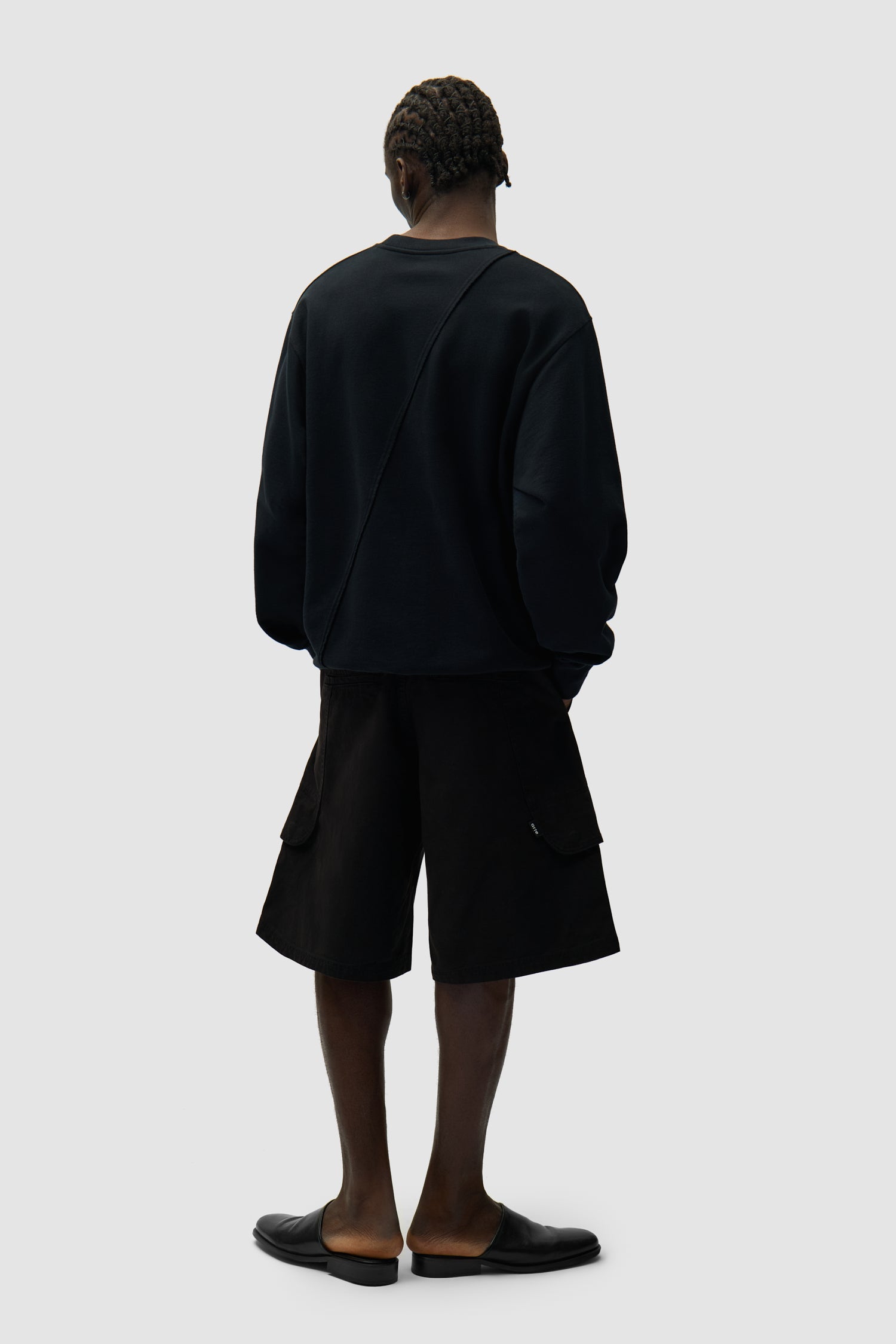 Pull noir avec logo brodé en cercle porté par un mannequin, vue arrière intégrale