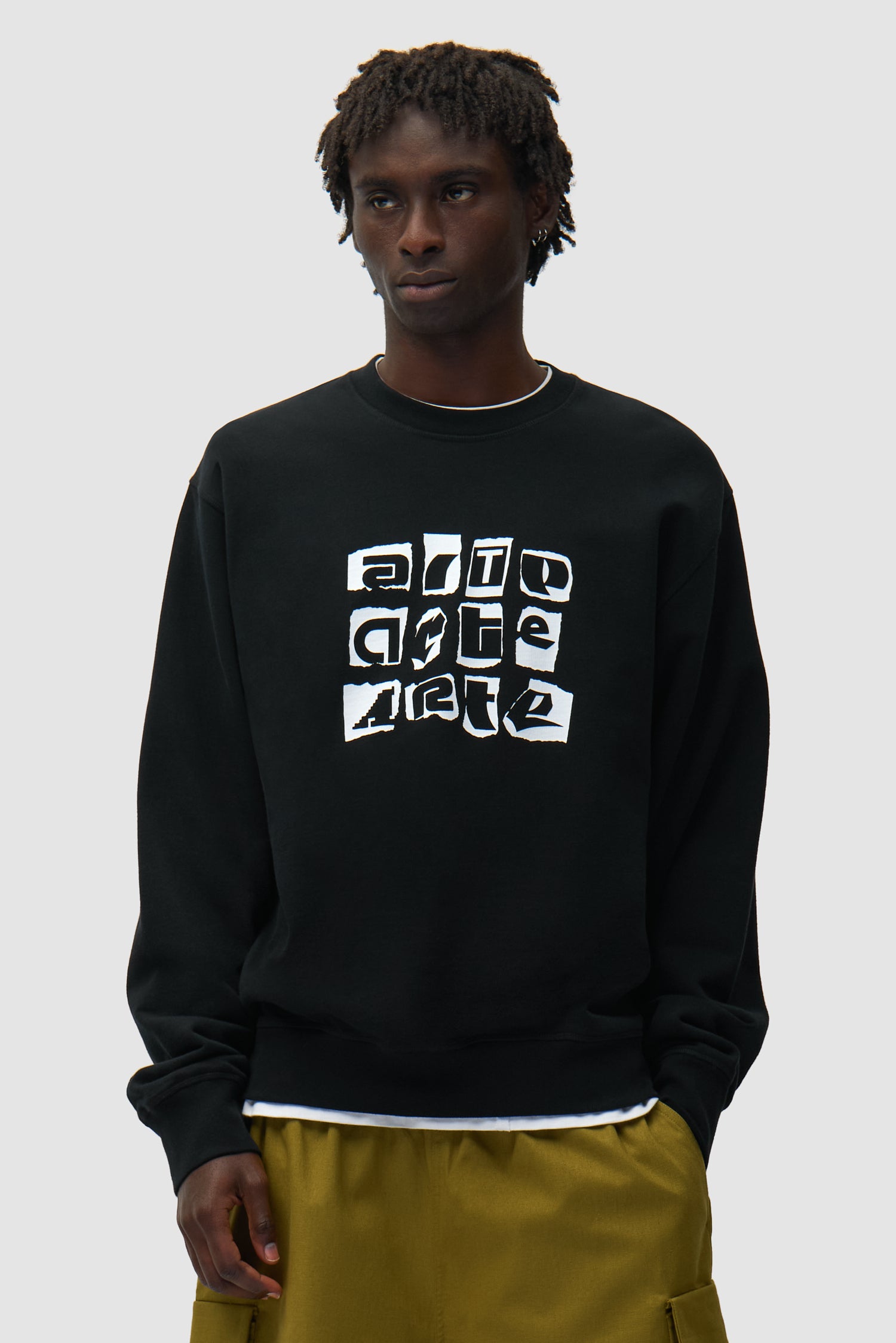 T-shirt à col rond et logo multiple, couleur noire, porté par un mannequin, vue de face, demi-corps