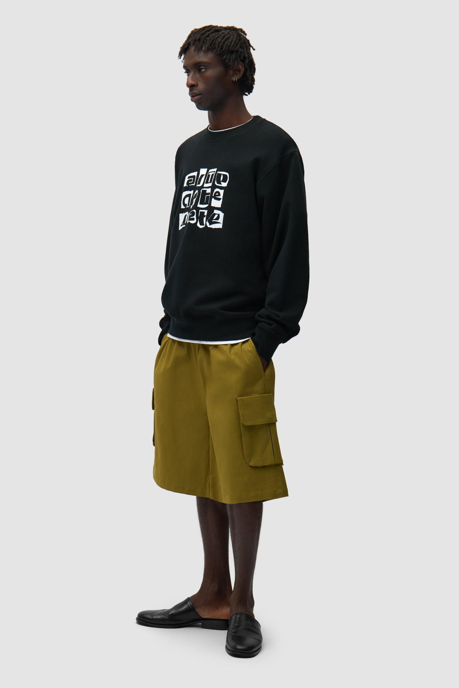 T-shirt à col rond noir avec plusieurs logos porté par un mannequin, vue de face en pied