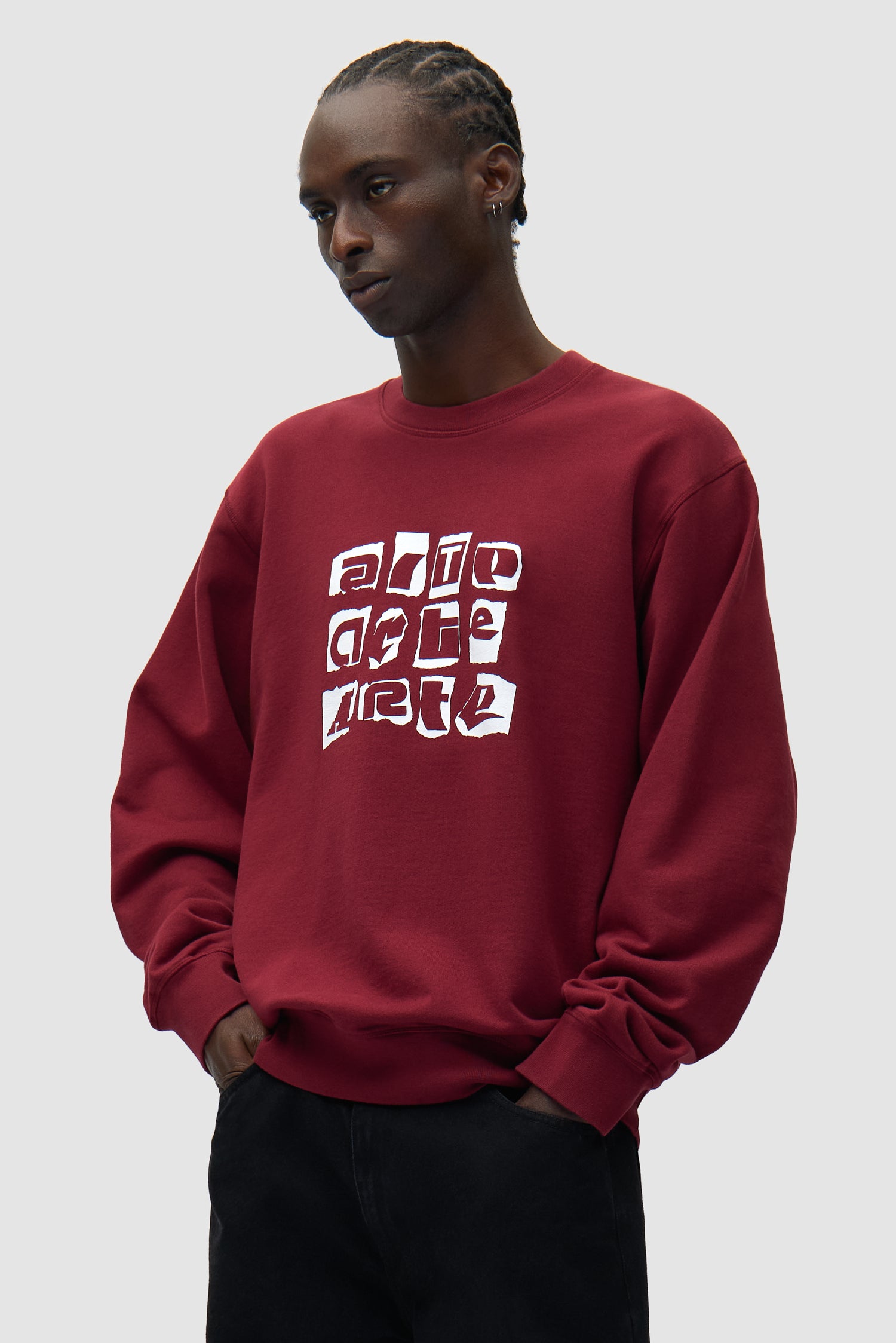 Pull à col rond multi-logos bordeaux porté par un mannequin, vue de face en demi-corps