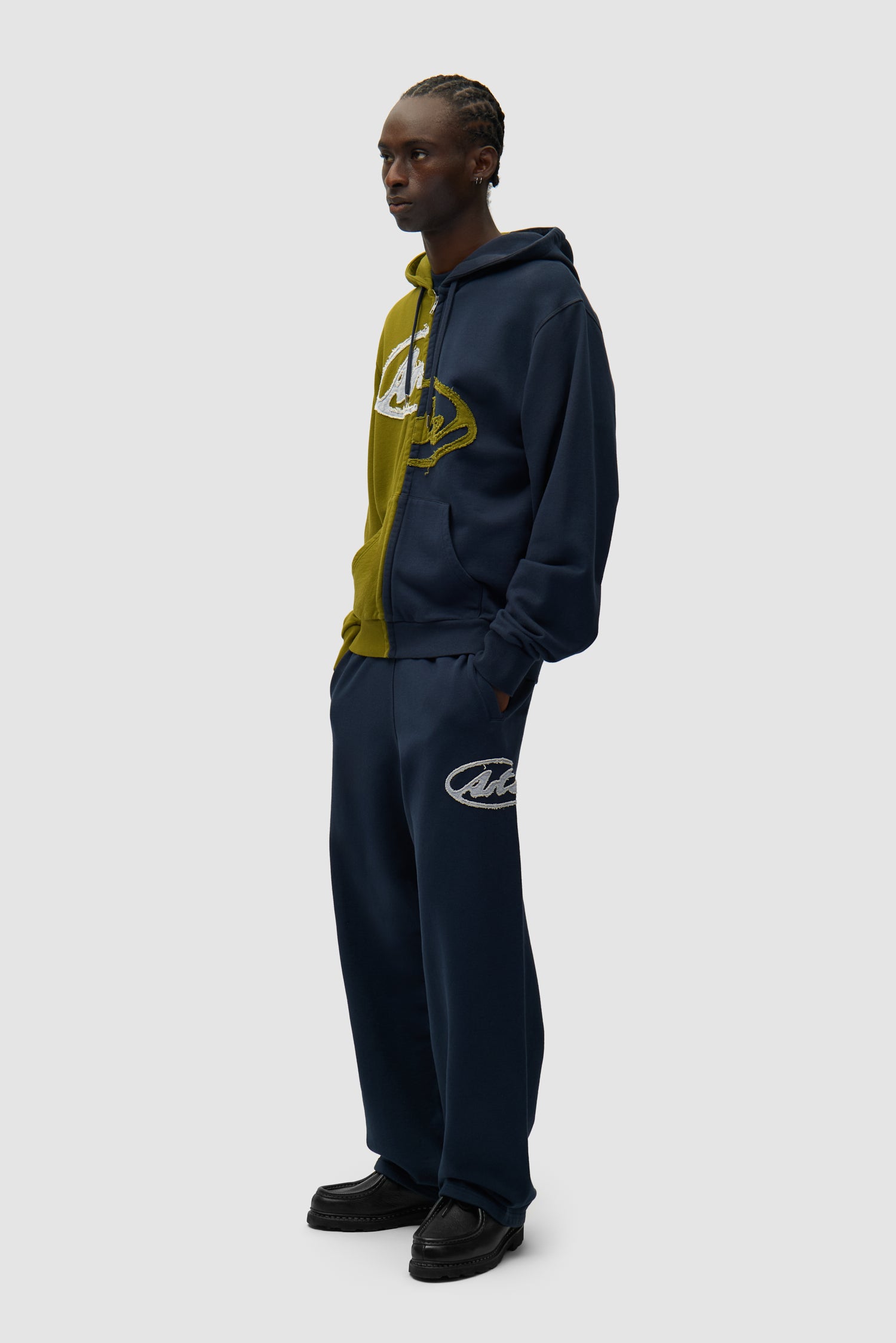 Sweat à capuche zippé Split Patch vert/bleu marine porté par un mannequin, vue de profil en pied