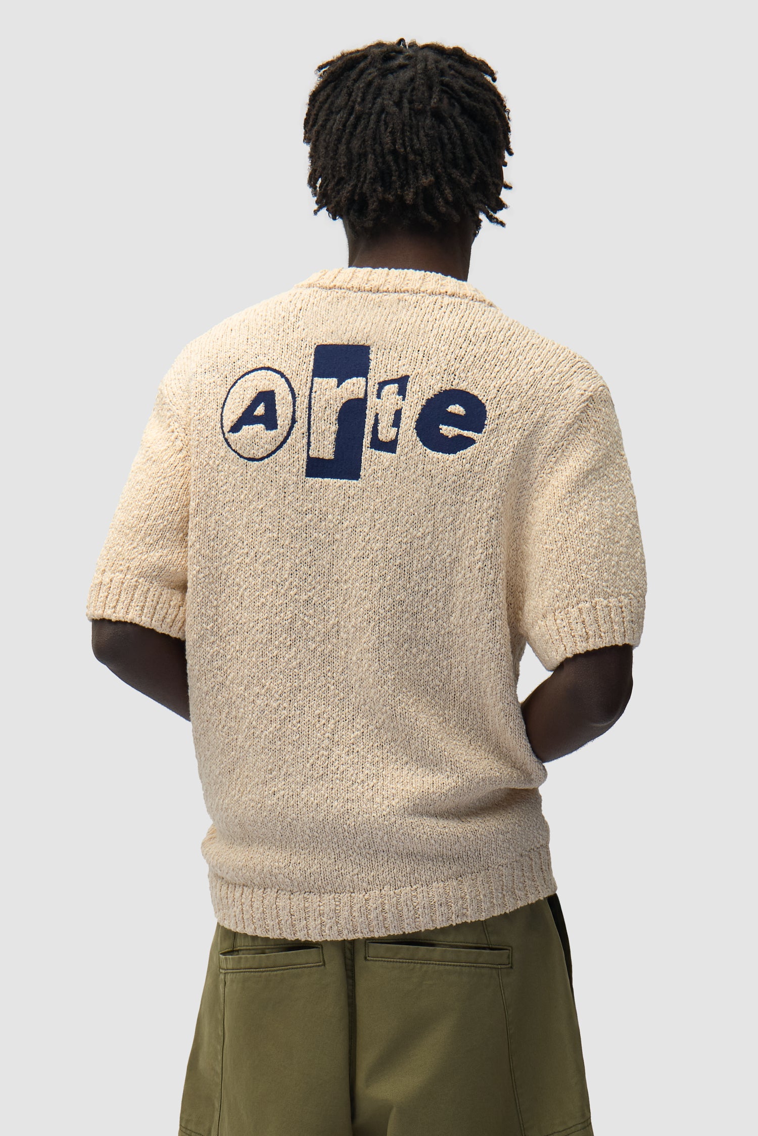 T-shirt en maille avec motif graphique dans le dos, couleur crème, porté par un mannequin, vue de dos à mi-corps