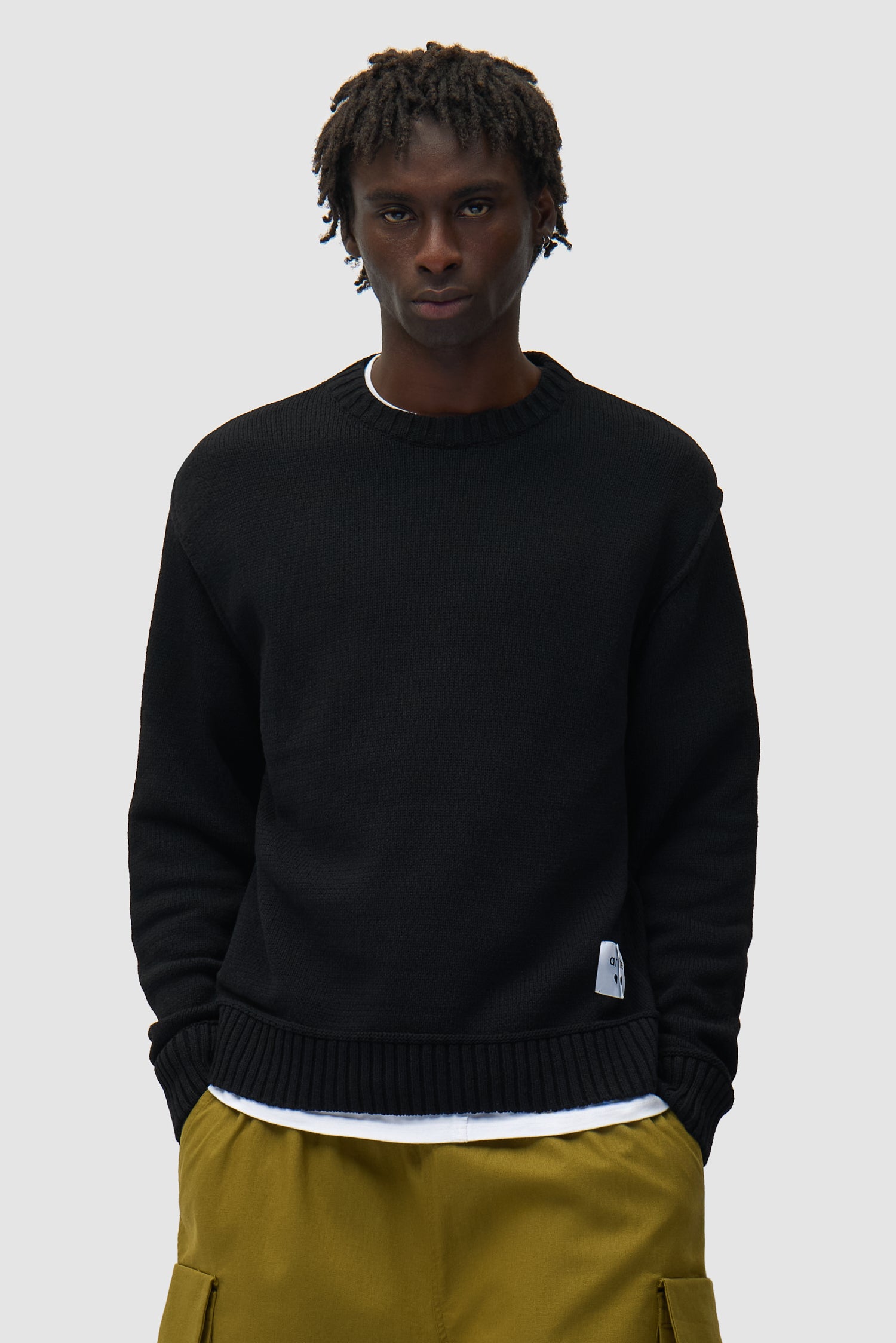 Étiquette réversible Tricot noir porté par un mannequin, vue de face en demi-corps