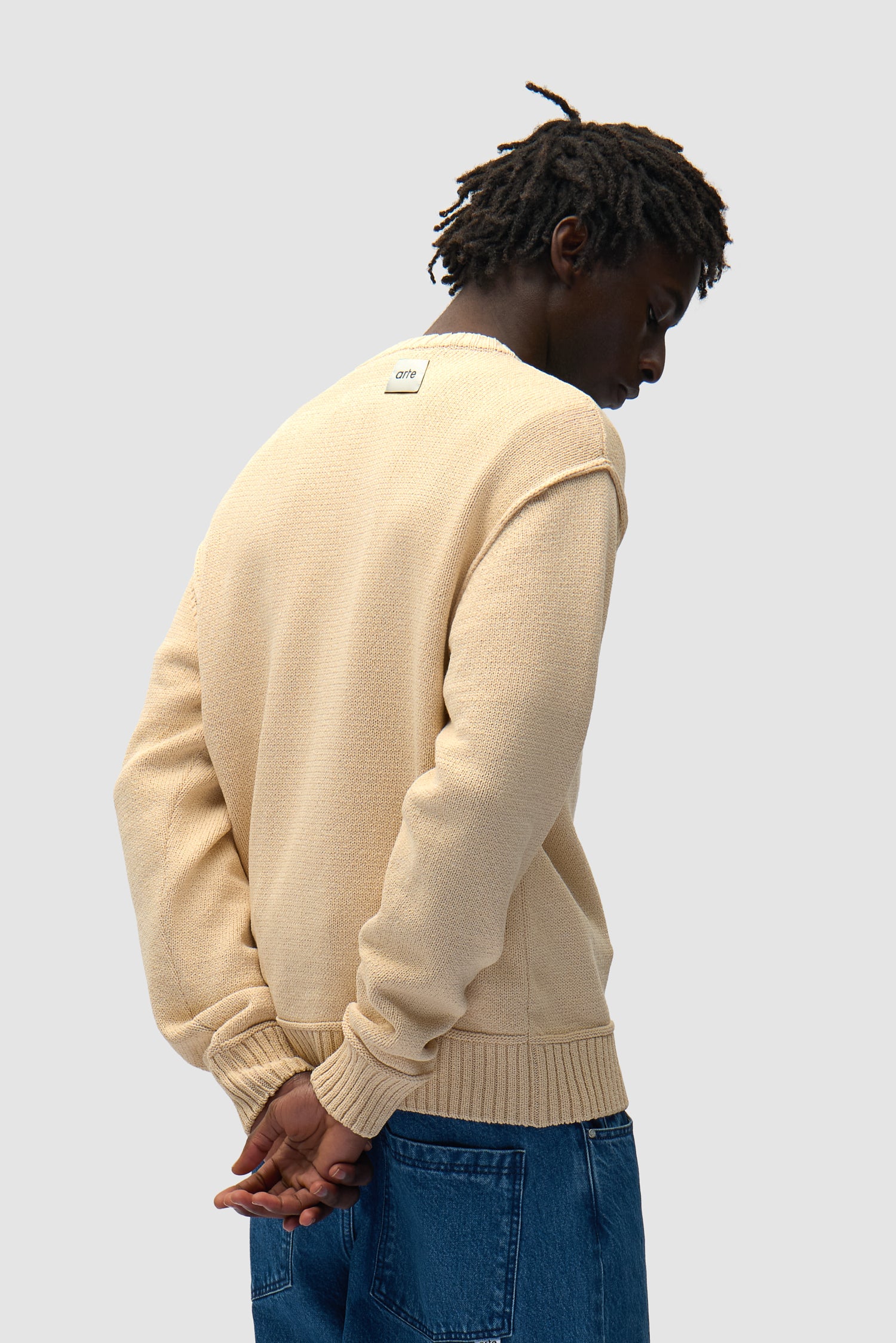 Reversible Label Knit in Cream Reversed worn by a model, half-body back view