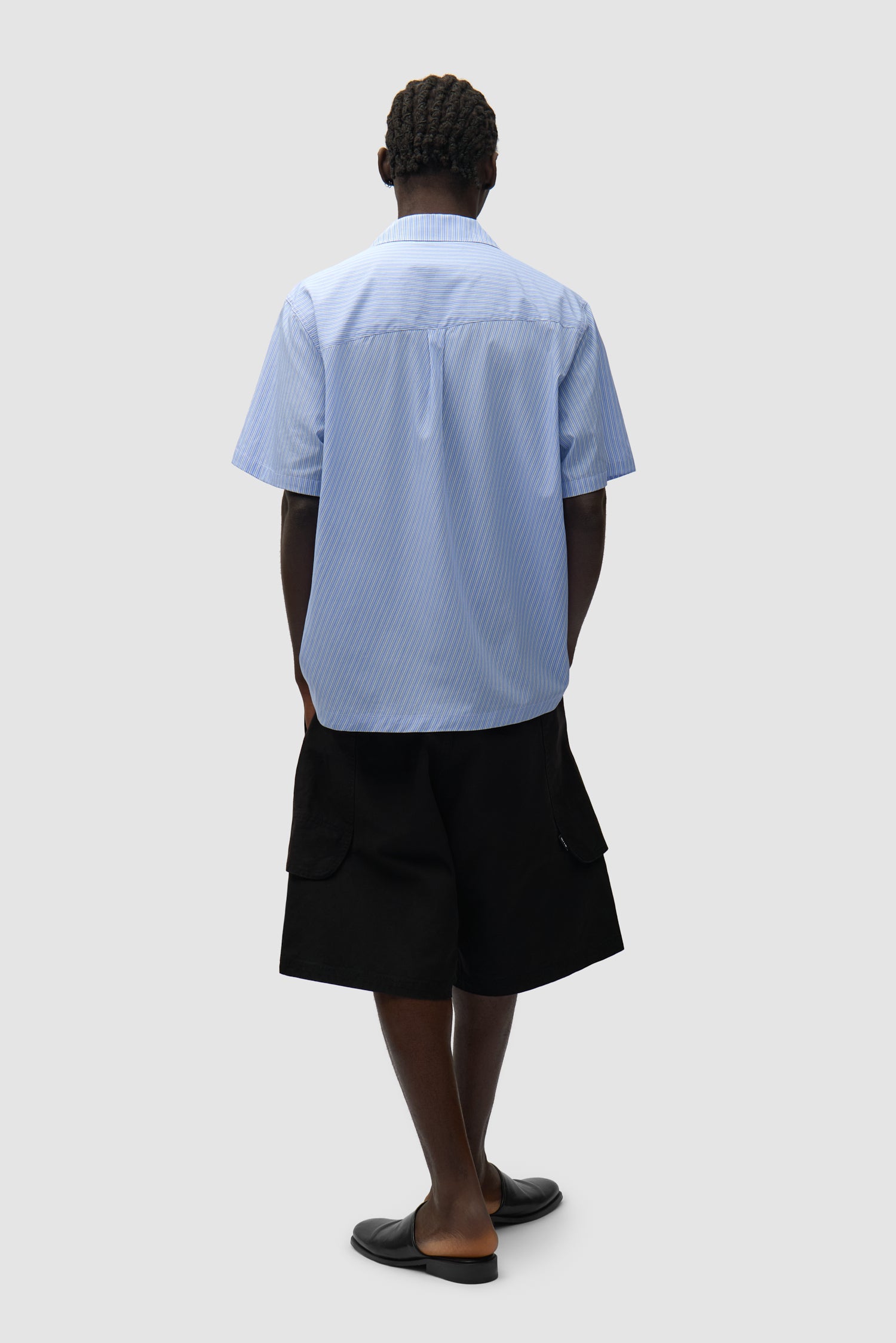 Chemise à poches plissées à rayures portée par un mannequin, vue arrière intégrale