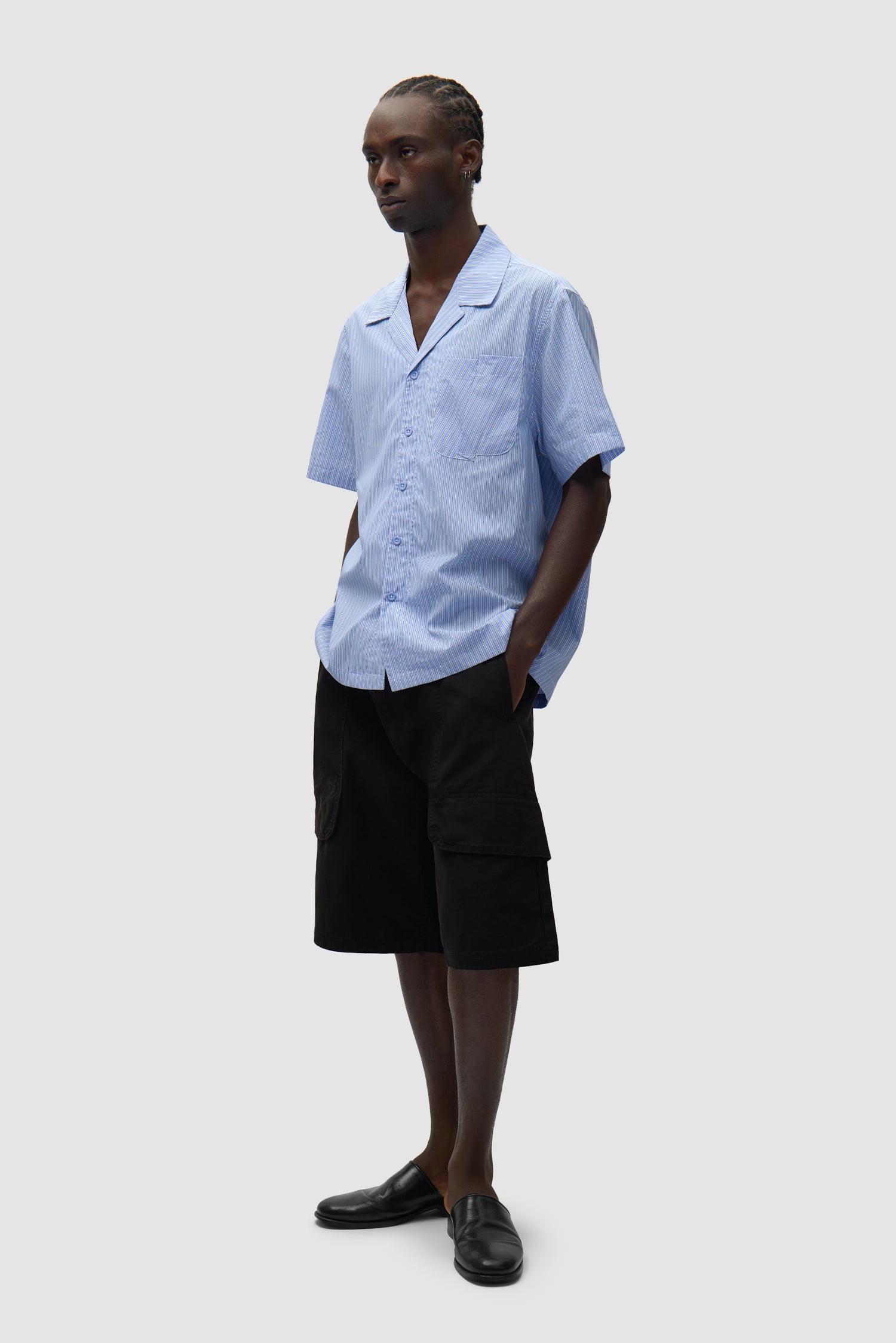 Chemise à poche plissée à rayures portée par un mannequin, vue de profil en pied