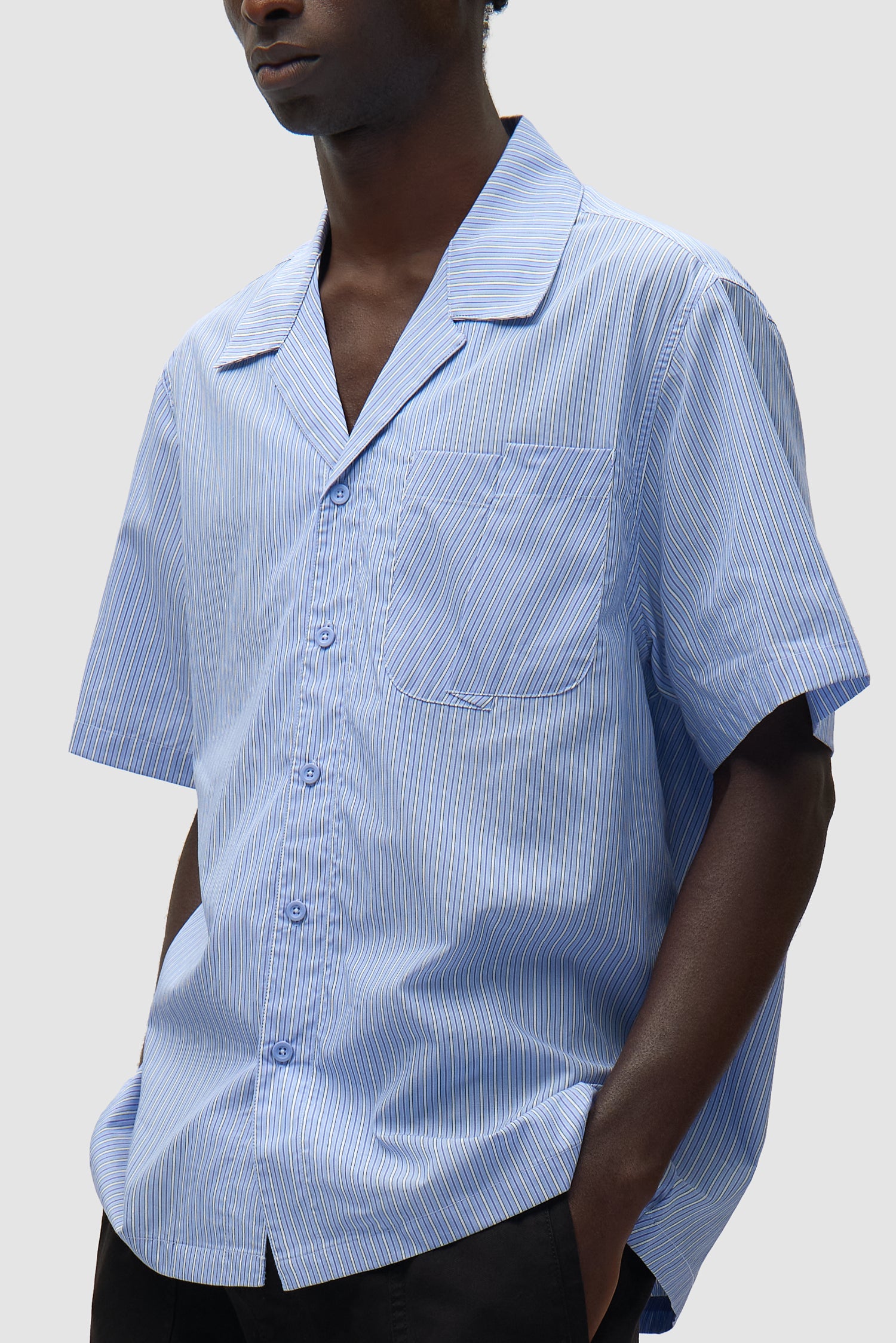 Chemise à poche plissée à rayures portée par un mannequin, vue de profil