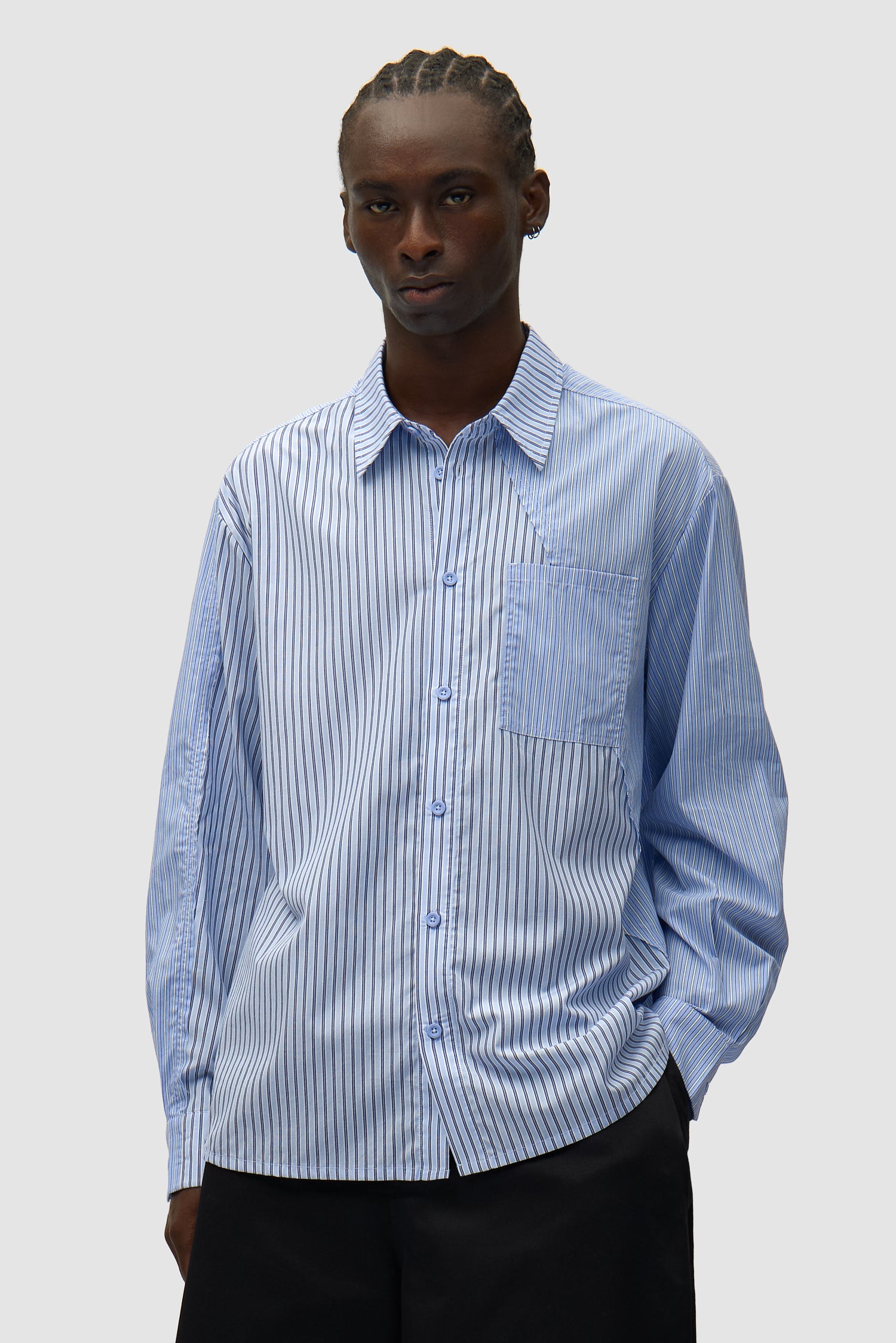 Chemise longue asymétrique à rayures portée par un mannequin, vue de face en demi-corps