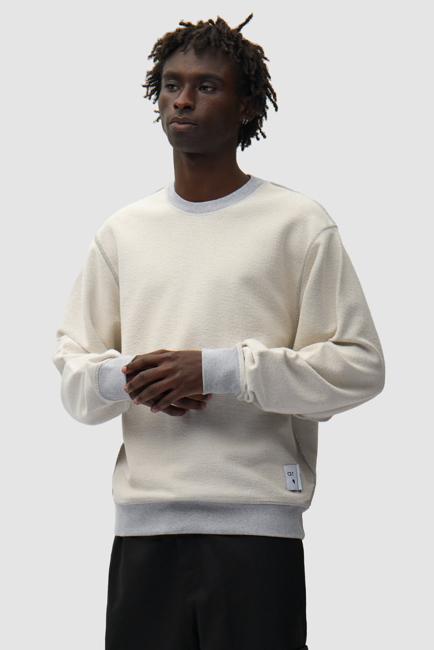 Étiquette réversible Sweat à col rond gris inversé porté par un mannequin, vue de face en demi-corps