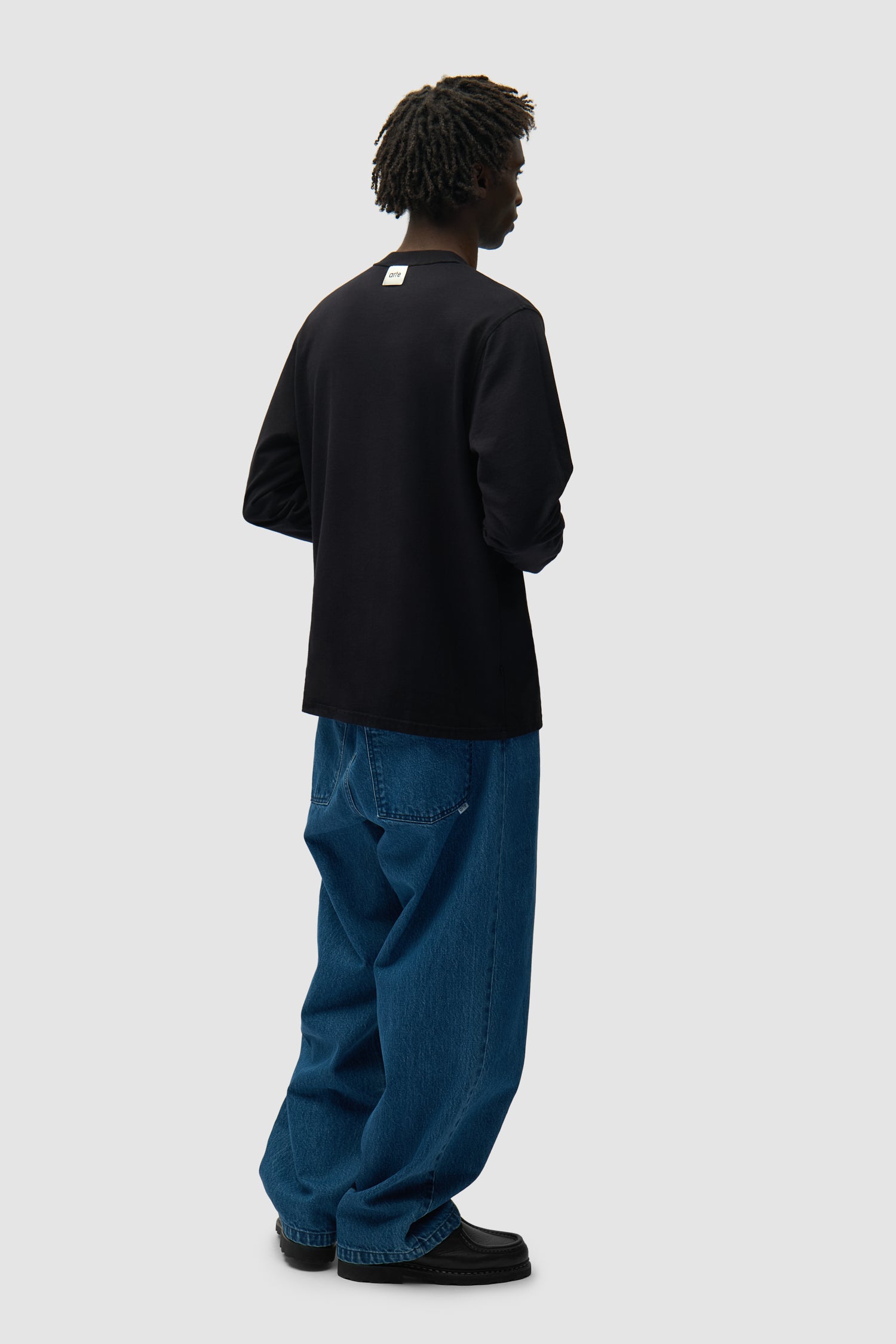 Étiquette réversible Longsleeve en noir porté à l'envers par un mannequin, vue arrière en pied