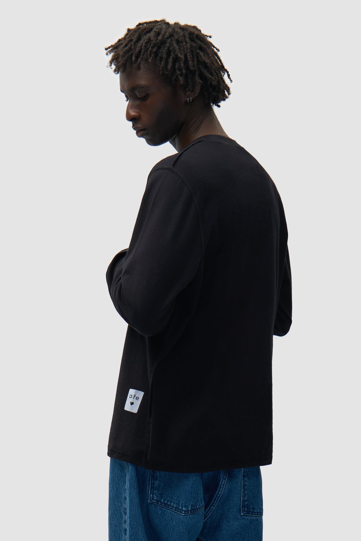 T-shirt à manches longues réversible noir porté par un mannequin, vue de profil à mi-corps