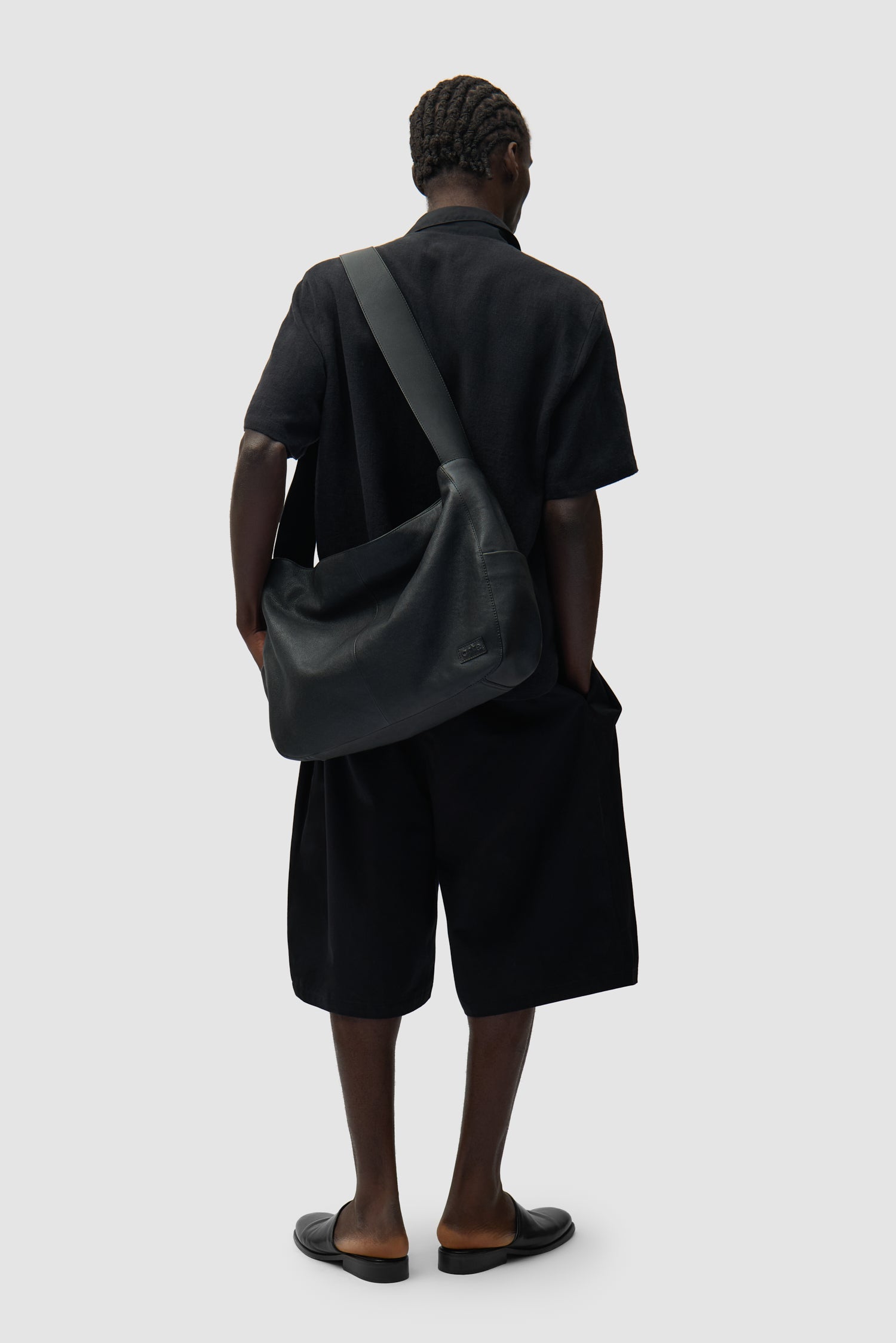 Sac en cuir oversize noir porté par un mannequin, vue en demi-corps