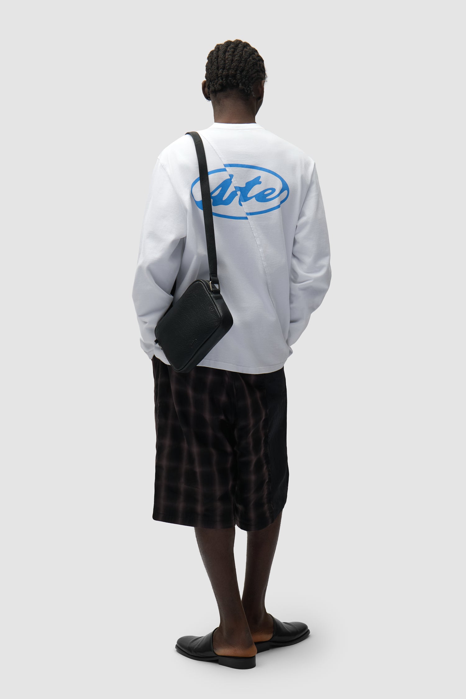 Sac Baka en cuir noir porté par un mannequin, vue de demi-corps