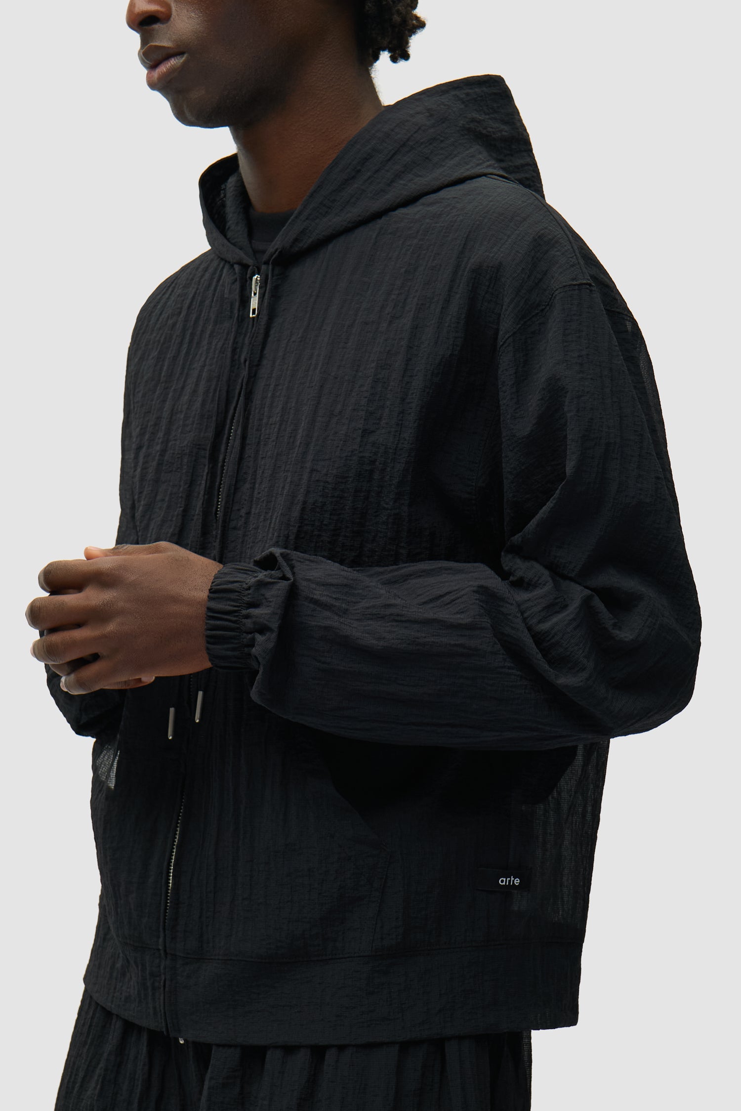 Veste en maille noire portée par un mannequin, vue détaillée du demi-corps