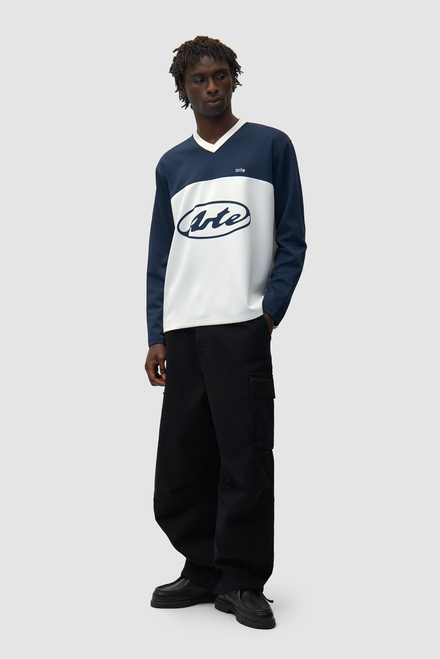 T-shirt à manches longues avec logo circulaire blanc/bleu marine porté par un mannequin, vue de profil en pied