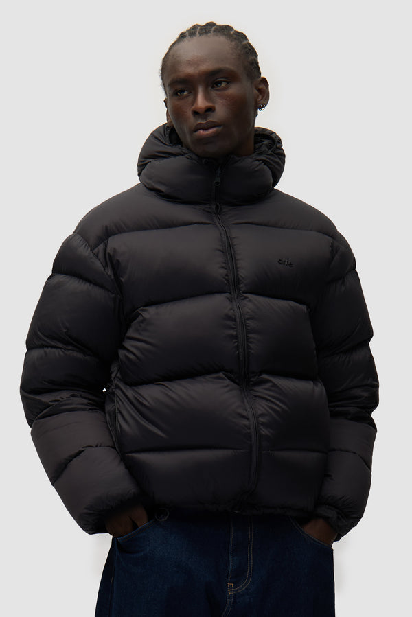 Reversible Puffer Jacket in Black worn by a model, half-body front view
