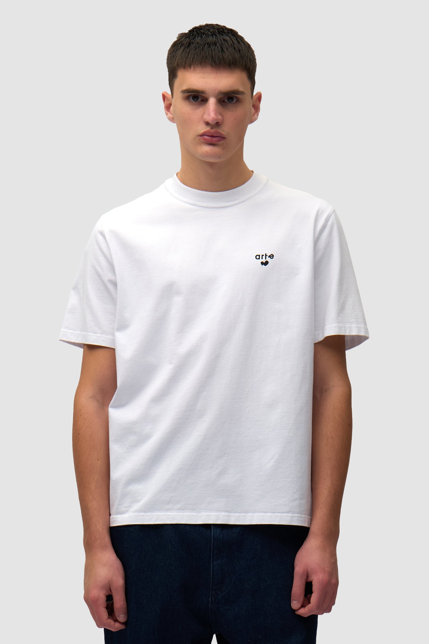 T-shirt blanc avec logo en forme de cœur porté par un mannequin, vue de face à mi-corps