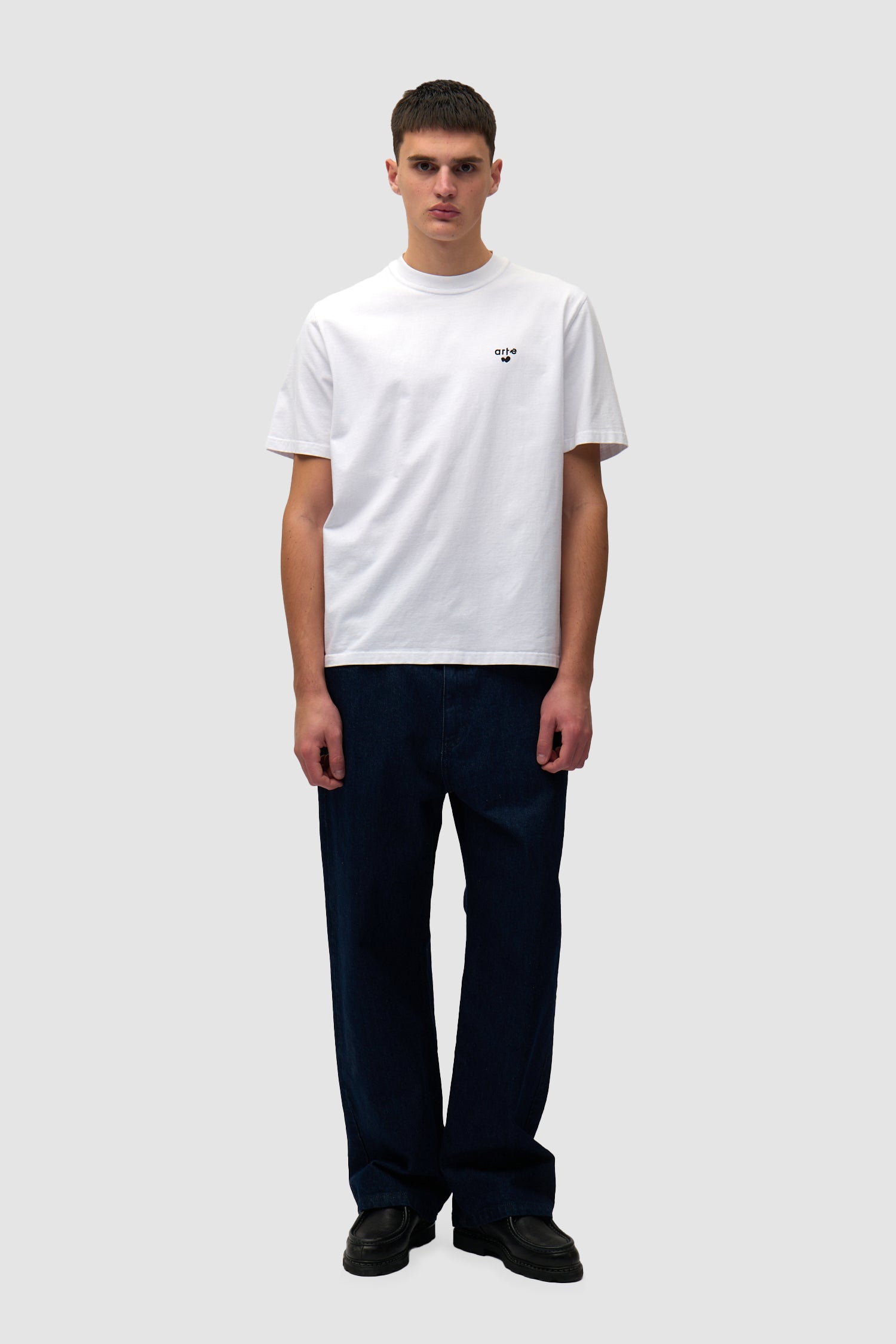 T-shirt blanc avec logo en forme de cœur porté par un mannequin, vue de face en pied