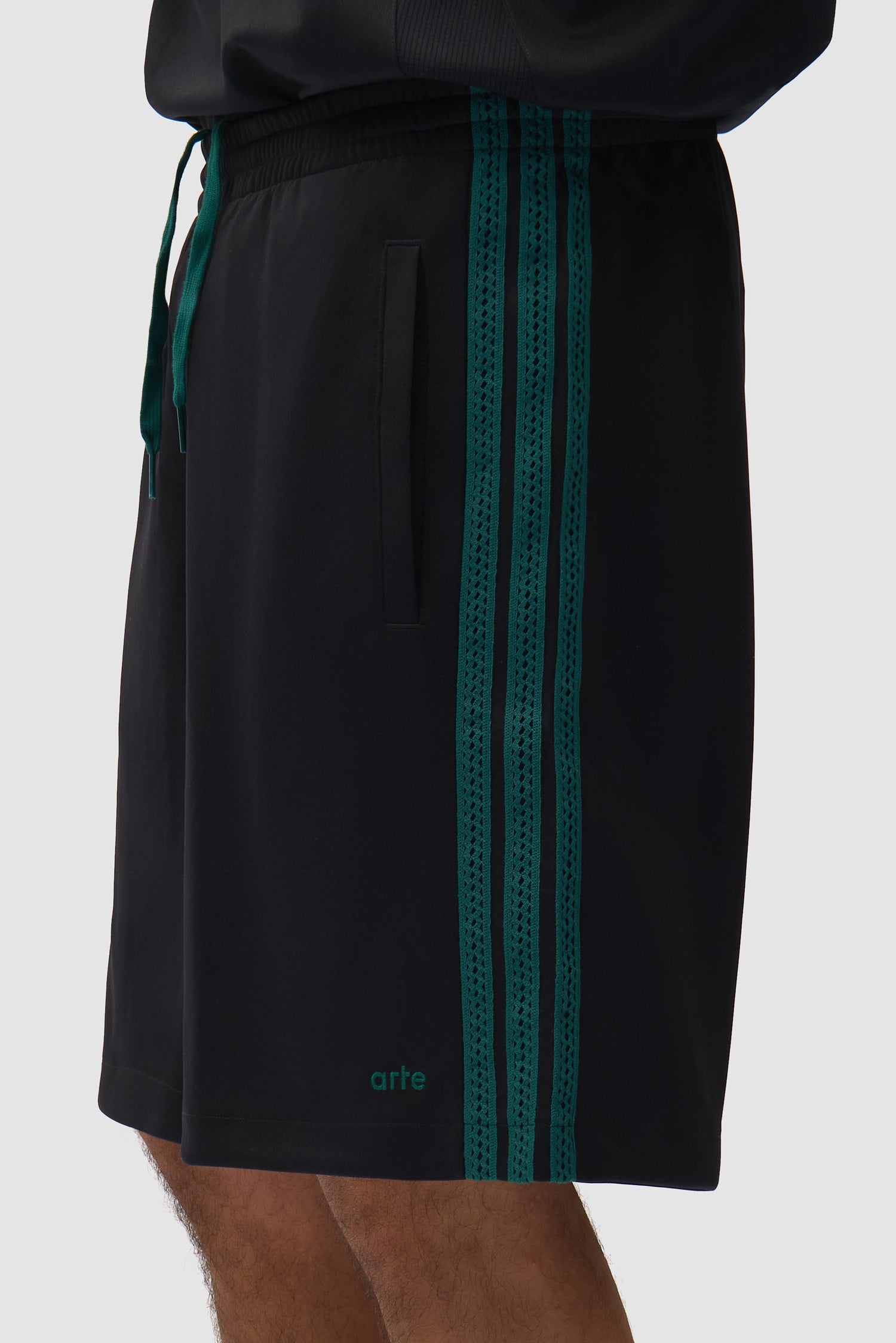 Vue détaillée du short Arte pour adidas en noir, avec bandes latérales
