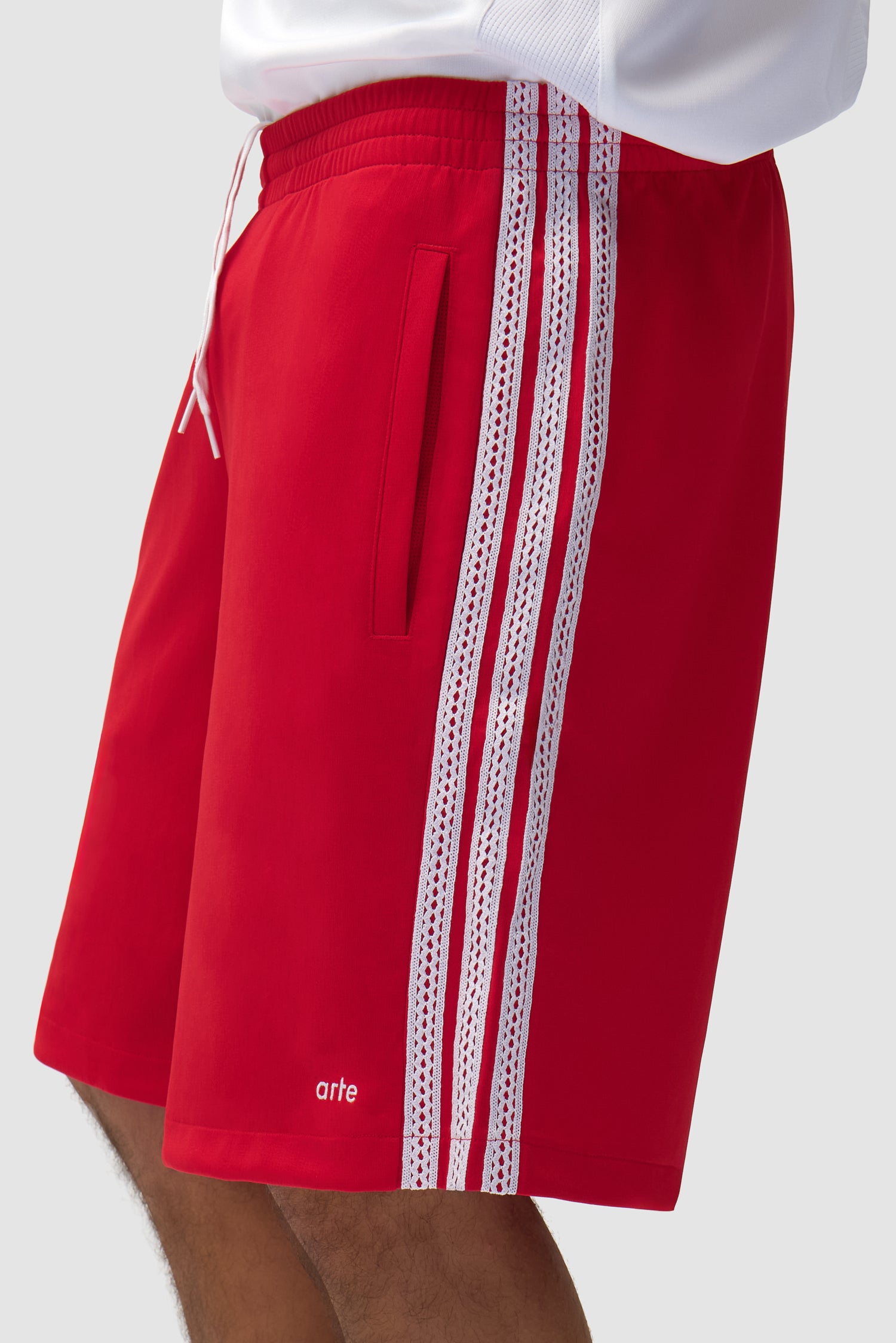 Vue détaillée du short Arte pour adidas en Better Scarlet, avec bandes latérales