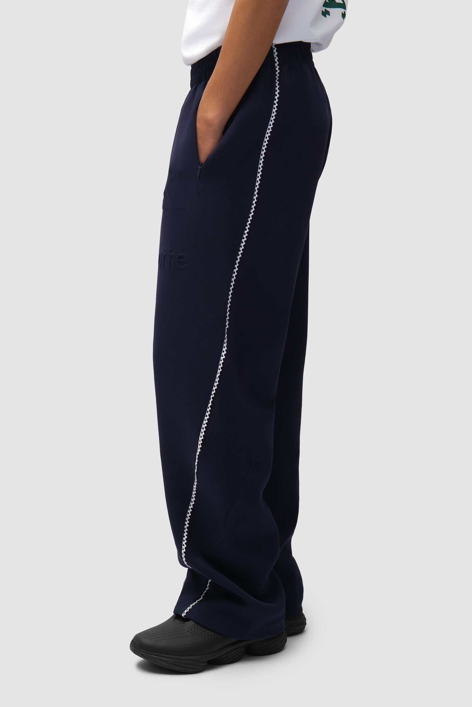 Pantalon Arte pour adidas Legend Ink/White porté par un mannequin, vue de profil à mi-corps