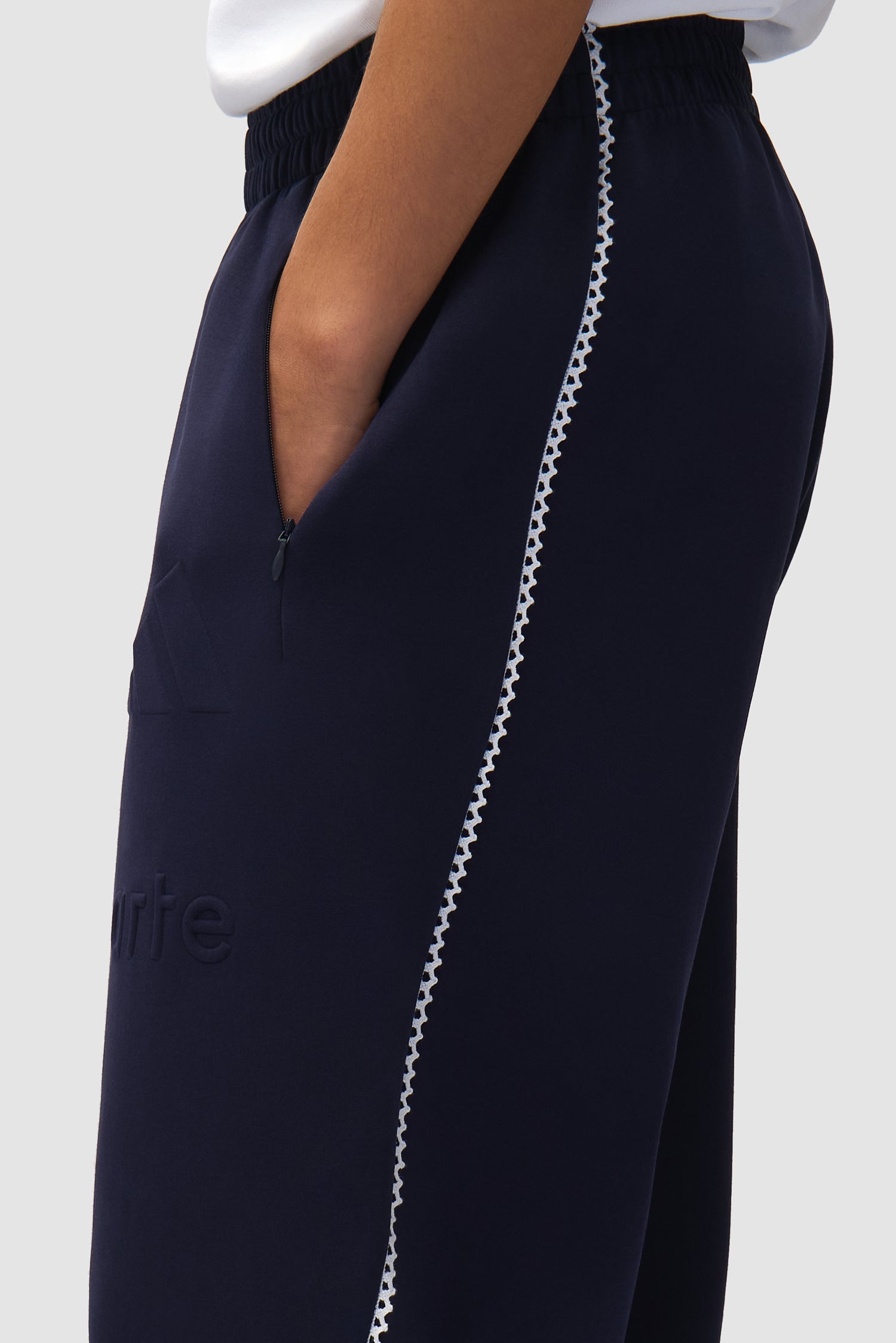 Vue détaillée du pantalon Arte pour adidas en Legend Ink/White, montrant la bande latérale