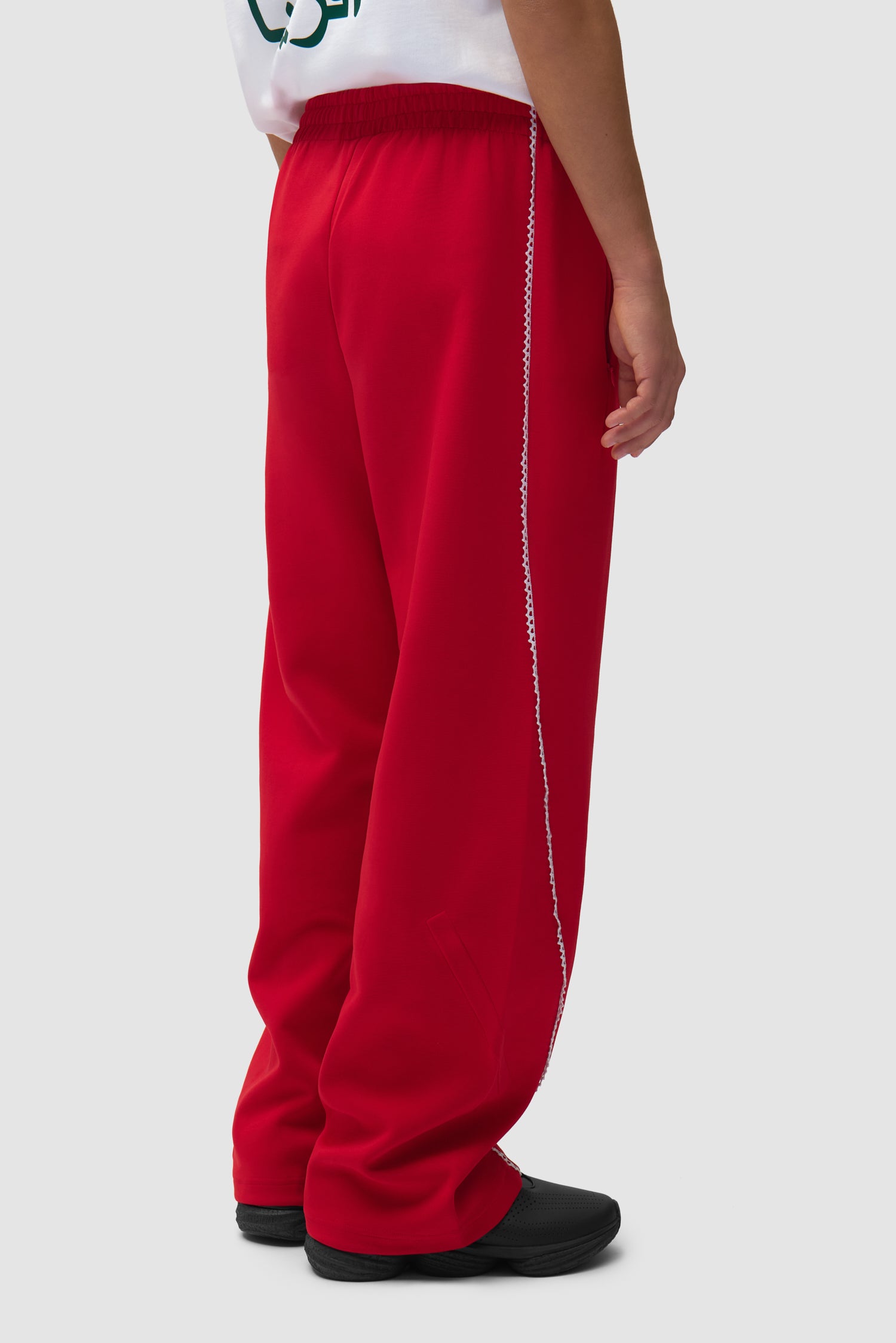 Pantalon Arte pour adidas Z.N.E. en Better Scarlet/White porté par un mannequin, vue de dos à mi-corps