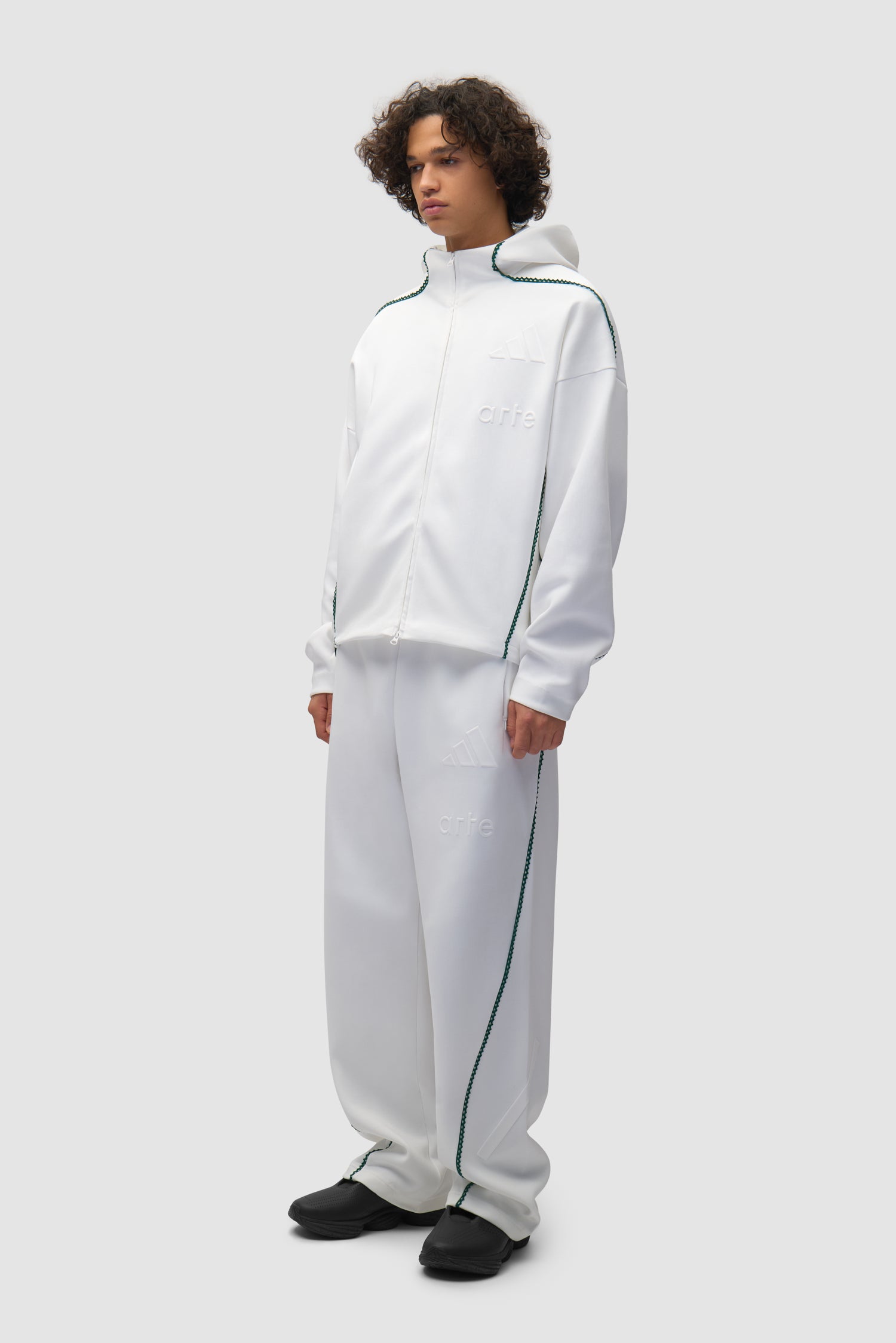 Veste Arte pour adidas Z.N.E. en blanc/Better Scarlet portée par un mannequin, vue de profil en pied