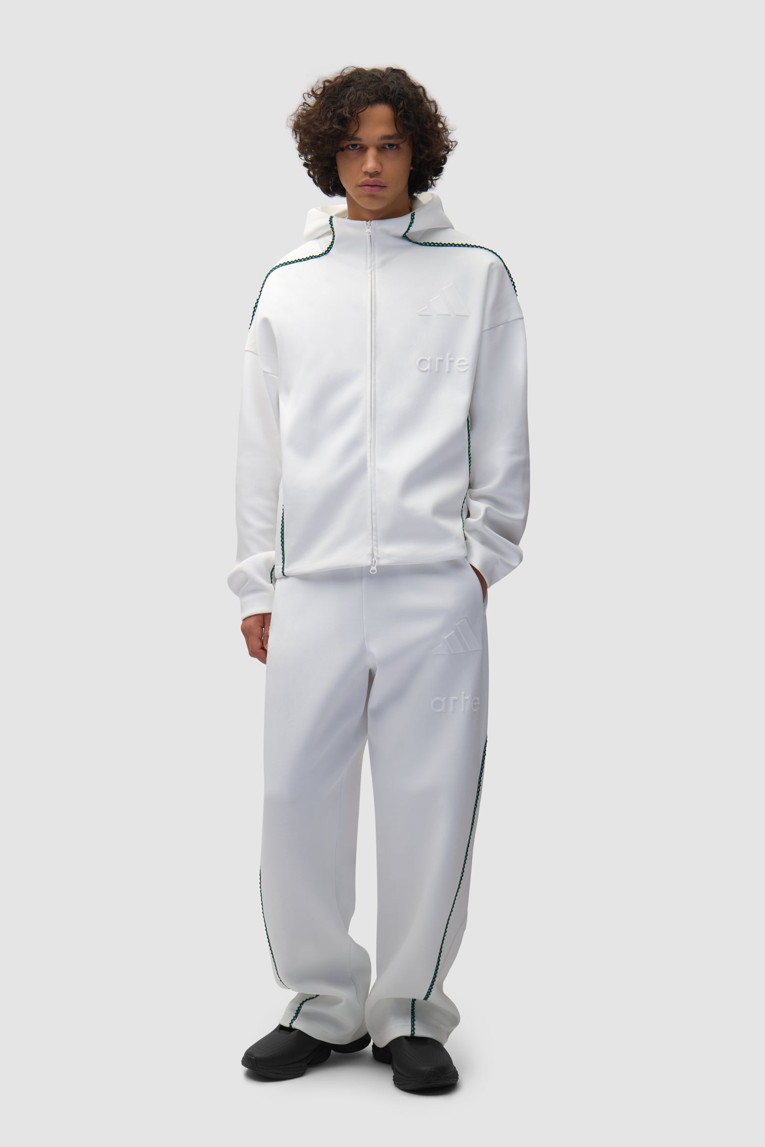 Pantalon Arte pour adidas Z.N.E. en blanc/Better Scarlet porté par un mannequin, vue de face en pied