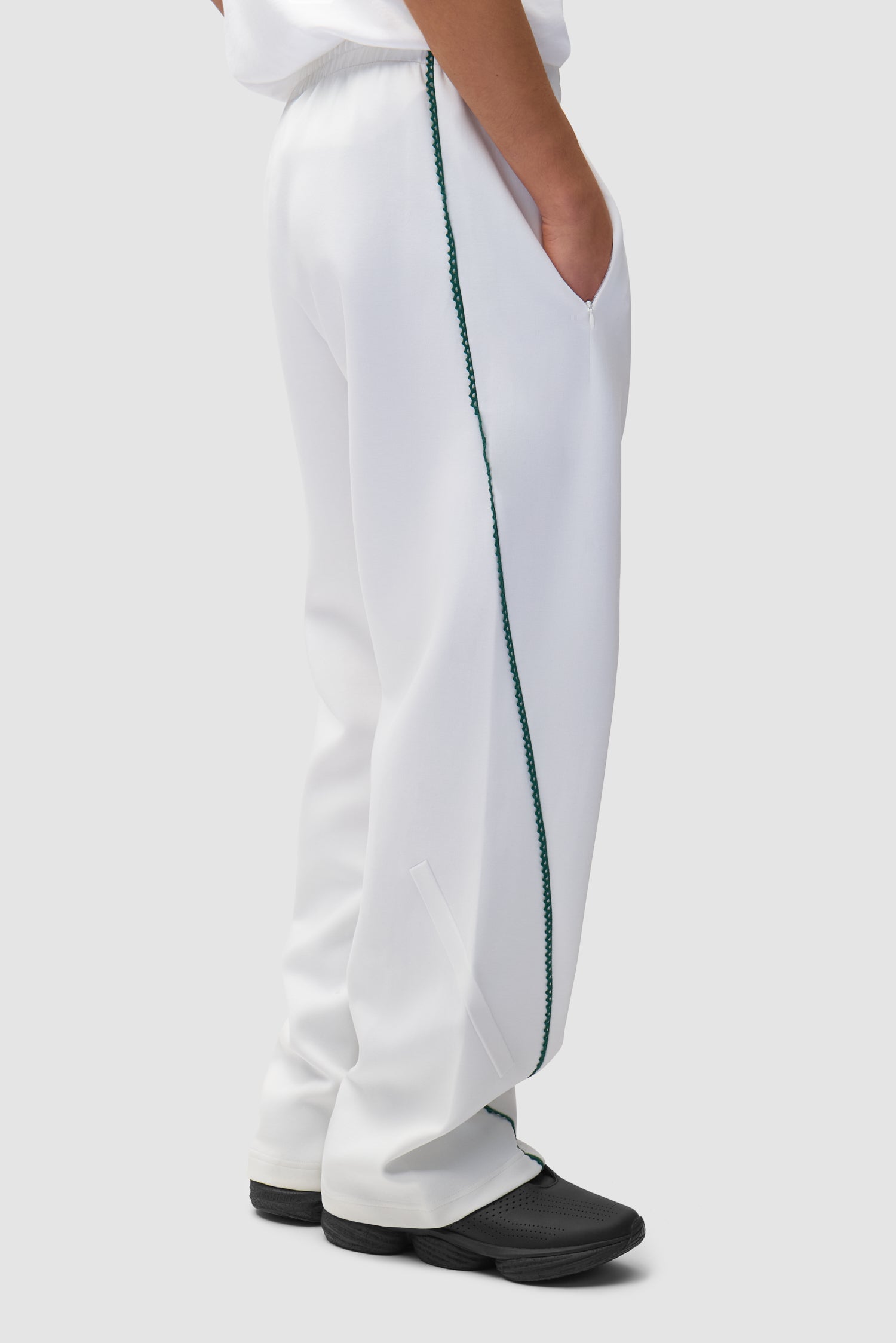 Pantalon Arte pour adidas Z.N.E. en blanc/Better Scarlet porté par un mannequin, vue de dos à mi-corps